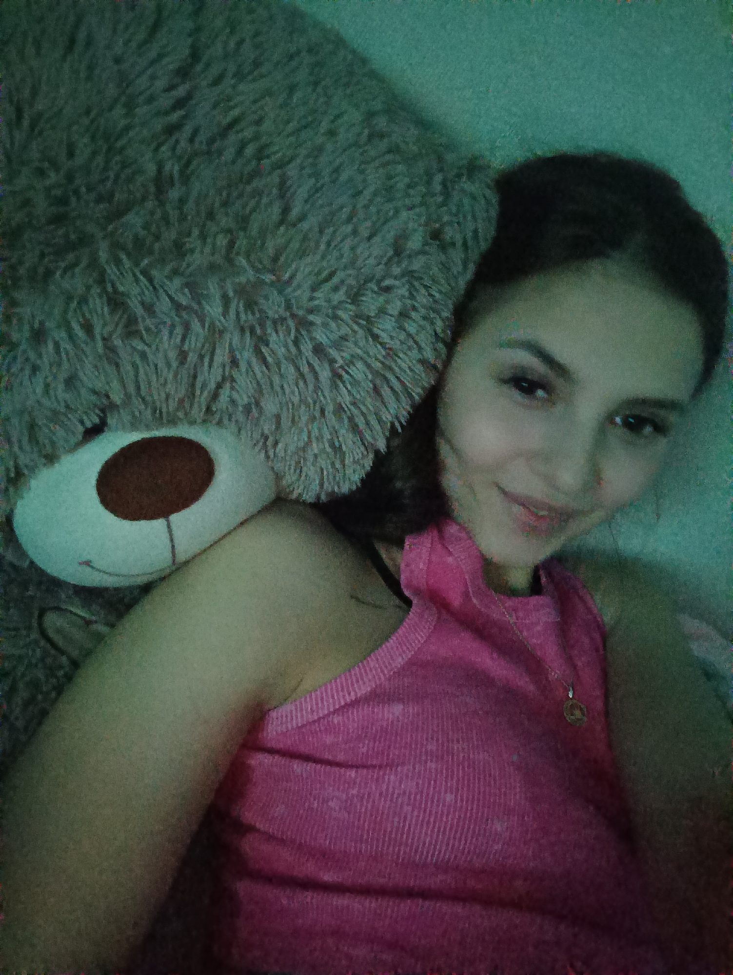 Woman photographed with teddy bear in indoor setting