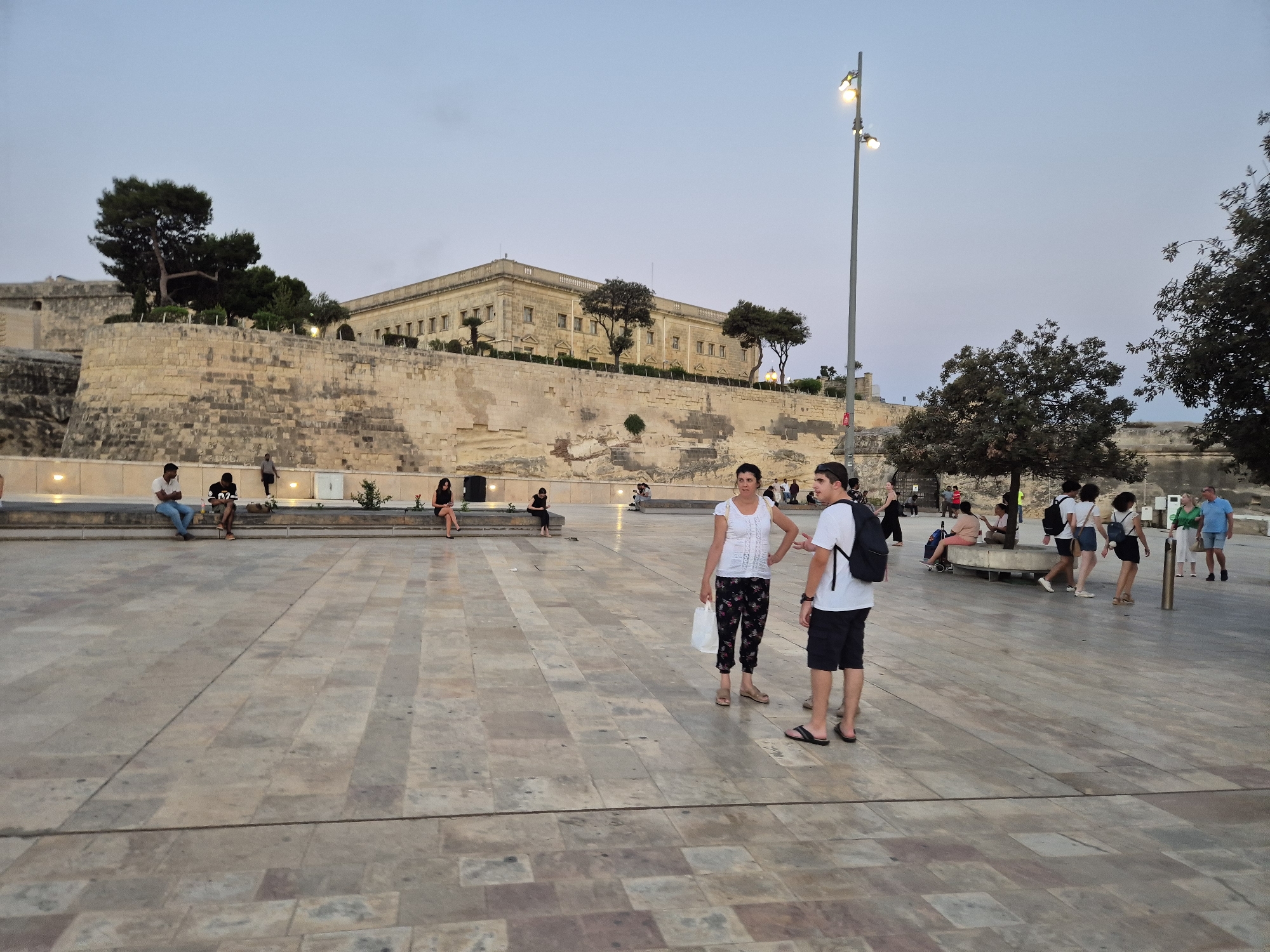 Valletta's City Gate precinct at dusk, people moving through