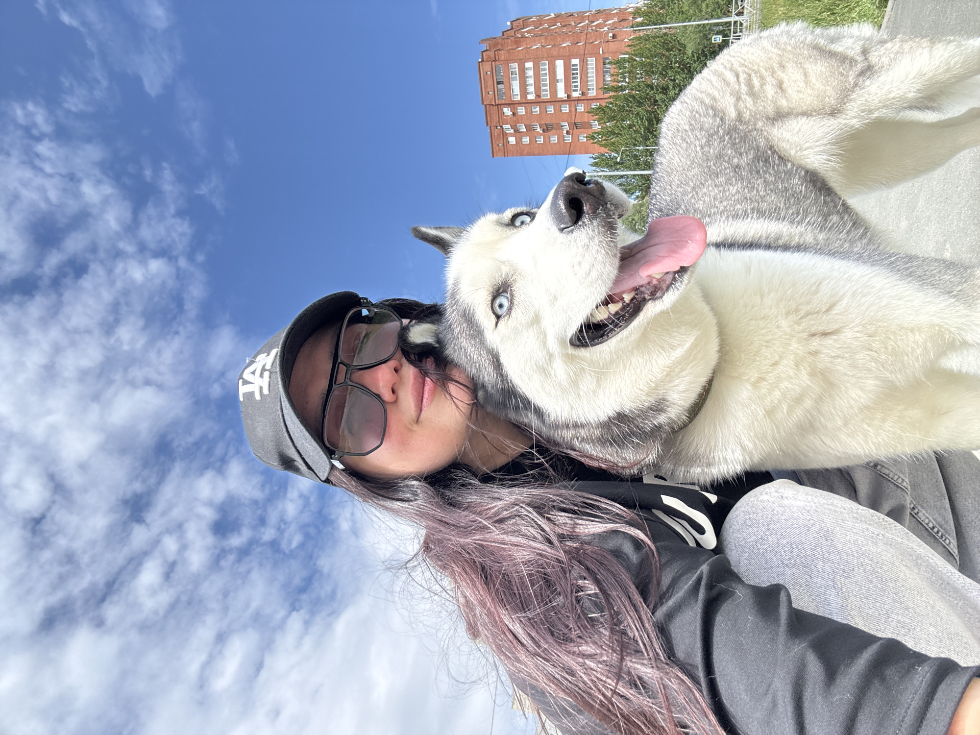 Woman and Siberian Husky photographed during sunny urban outing