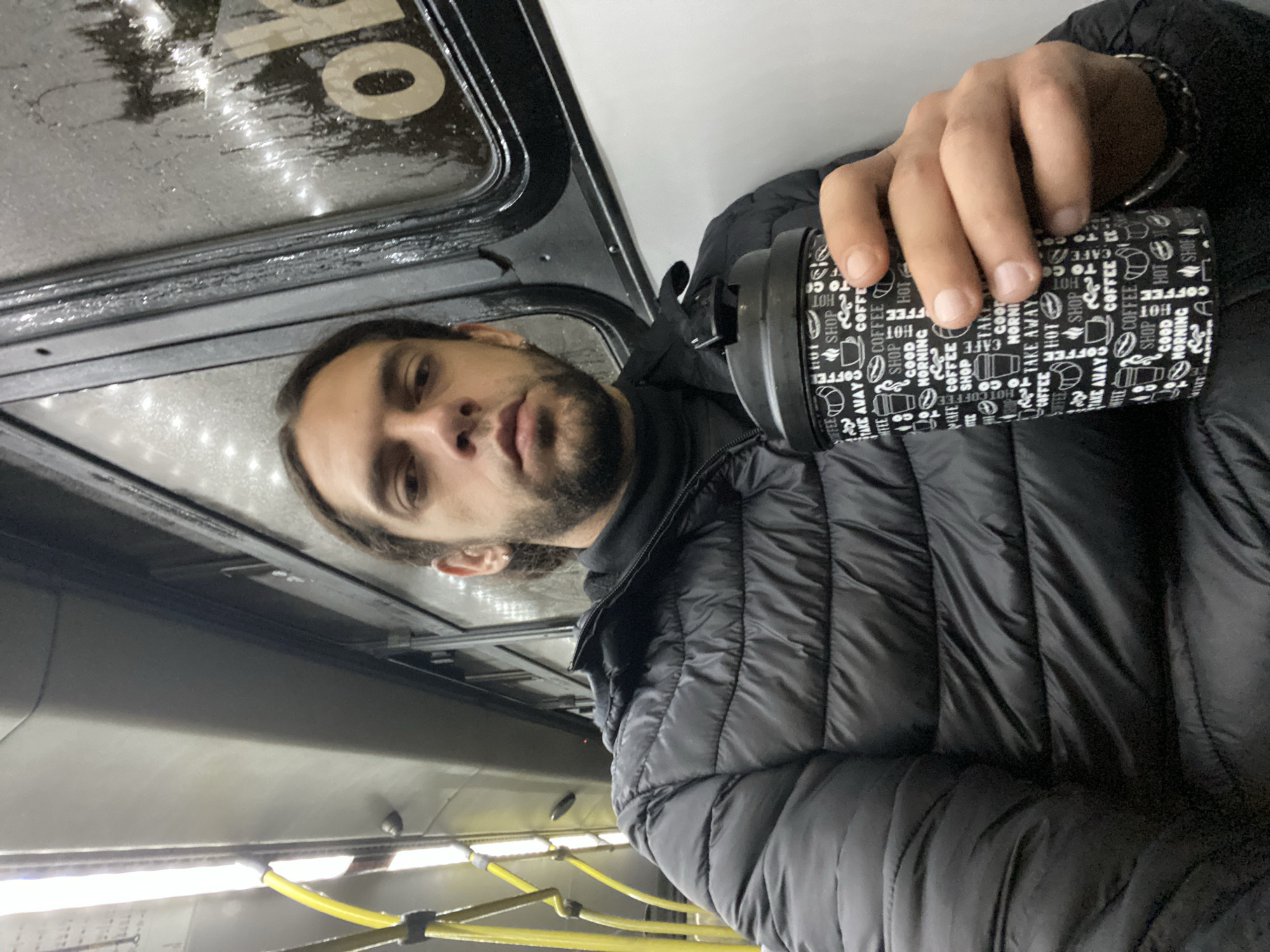 Morning commuter drinks coffee on Buenos Aires public transport