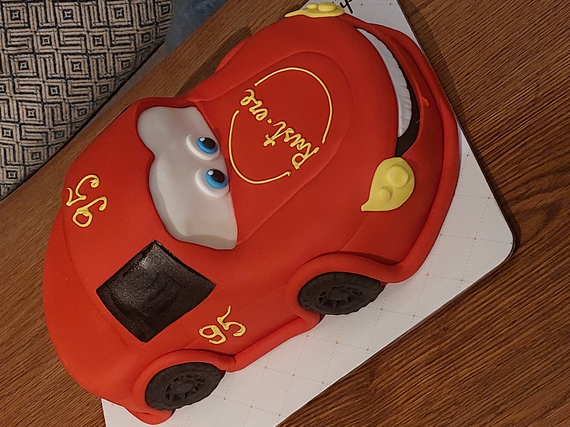 Celebration items captured: themed cake, flower arrangements, rose bouquet