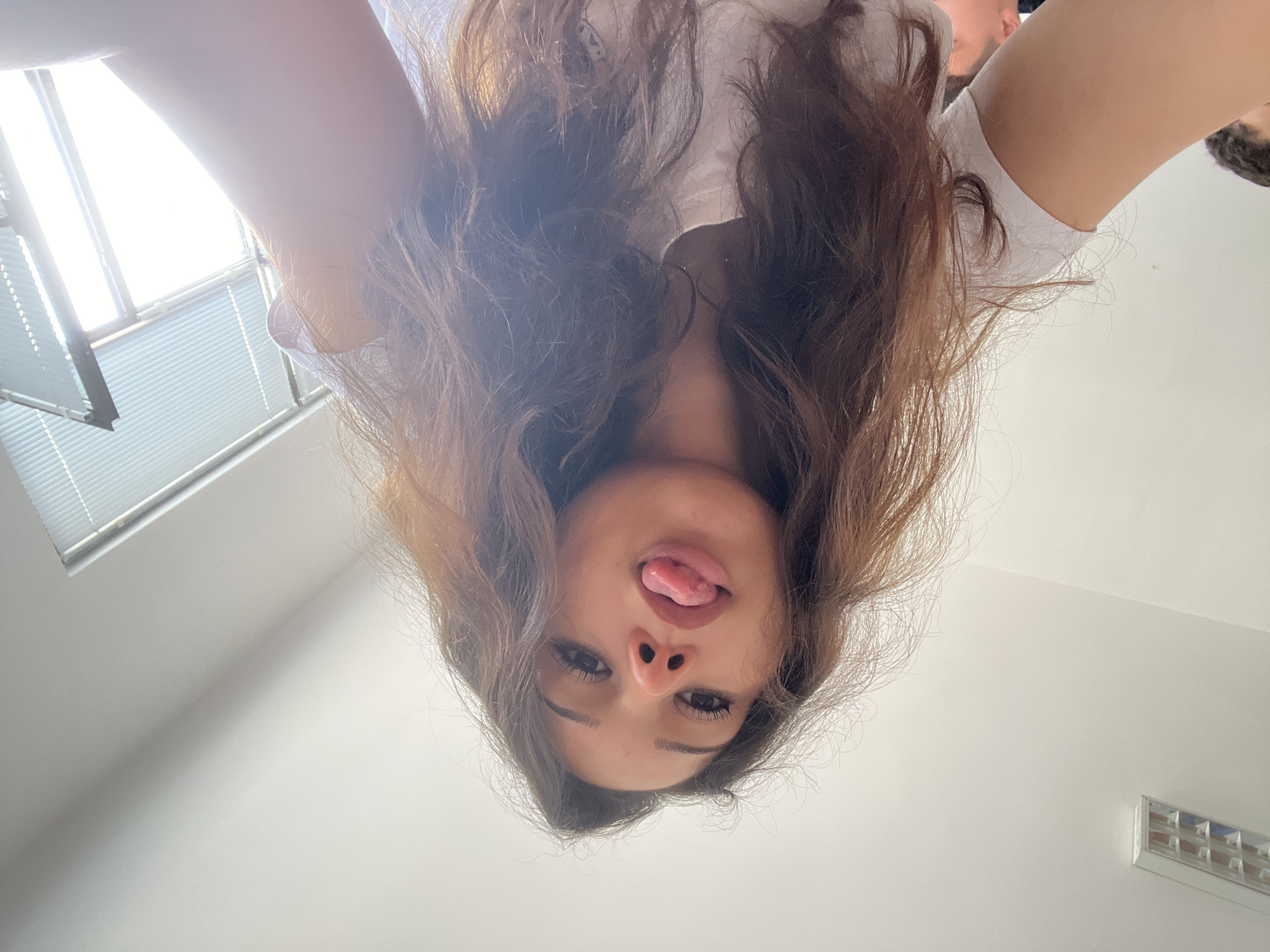 Woman takes playful selfies from multiple angles indoors