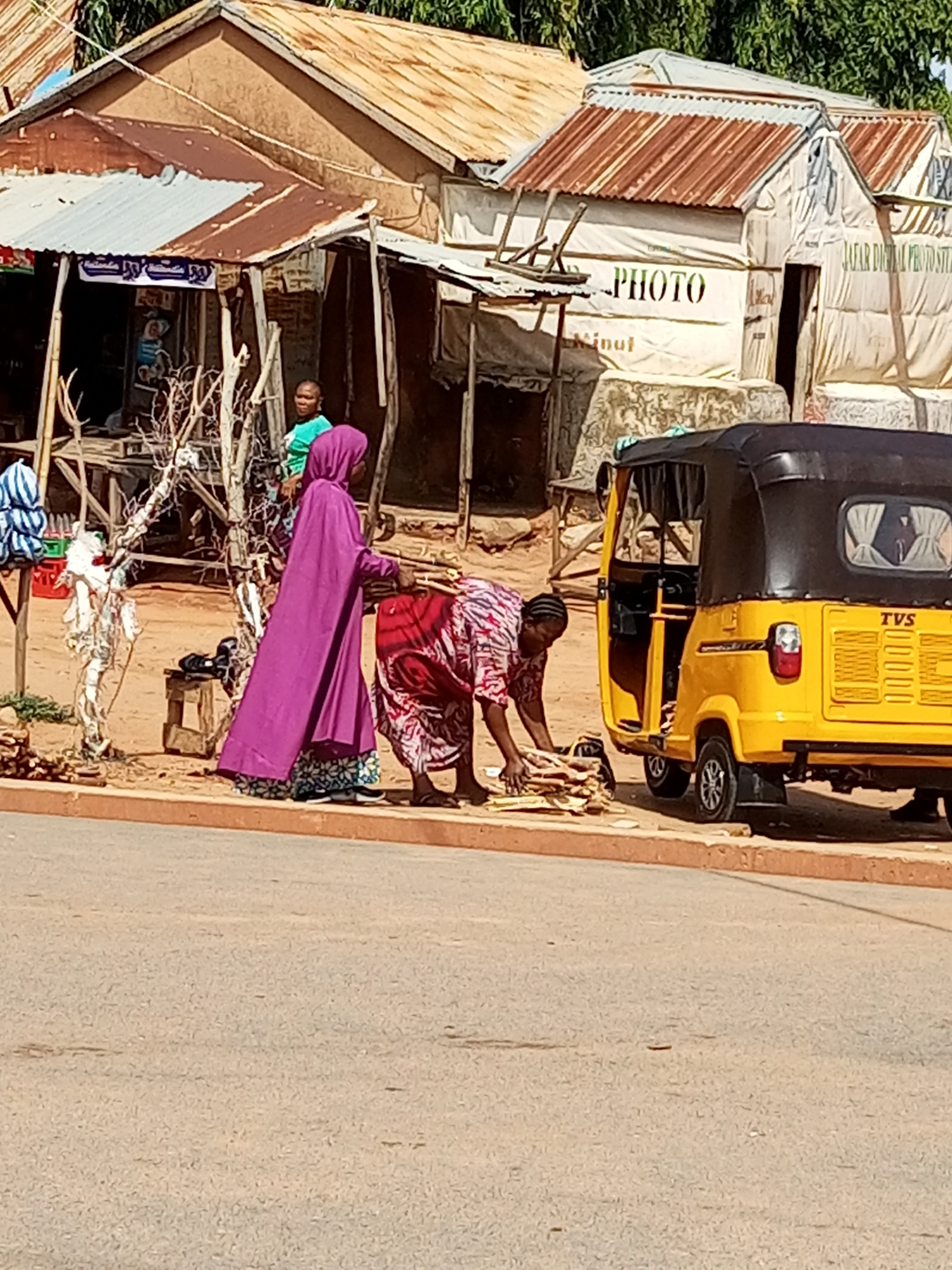 Firewood and daily life in a dusty urban setting.