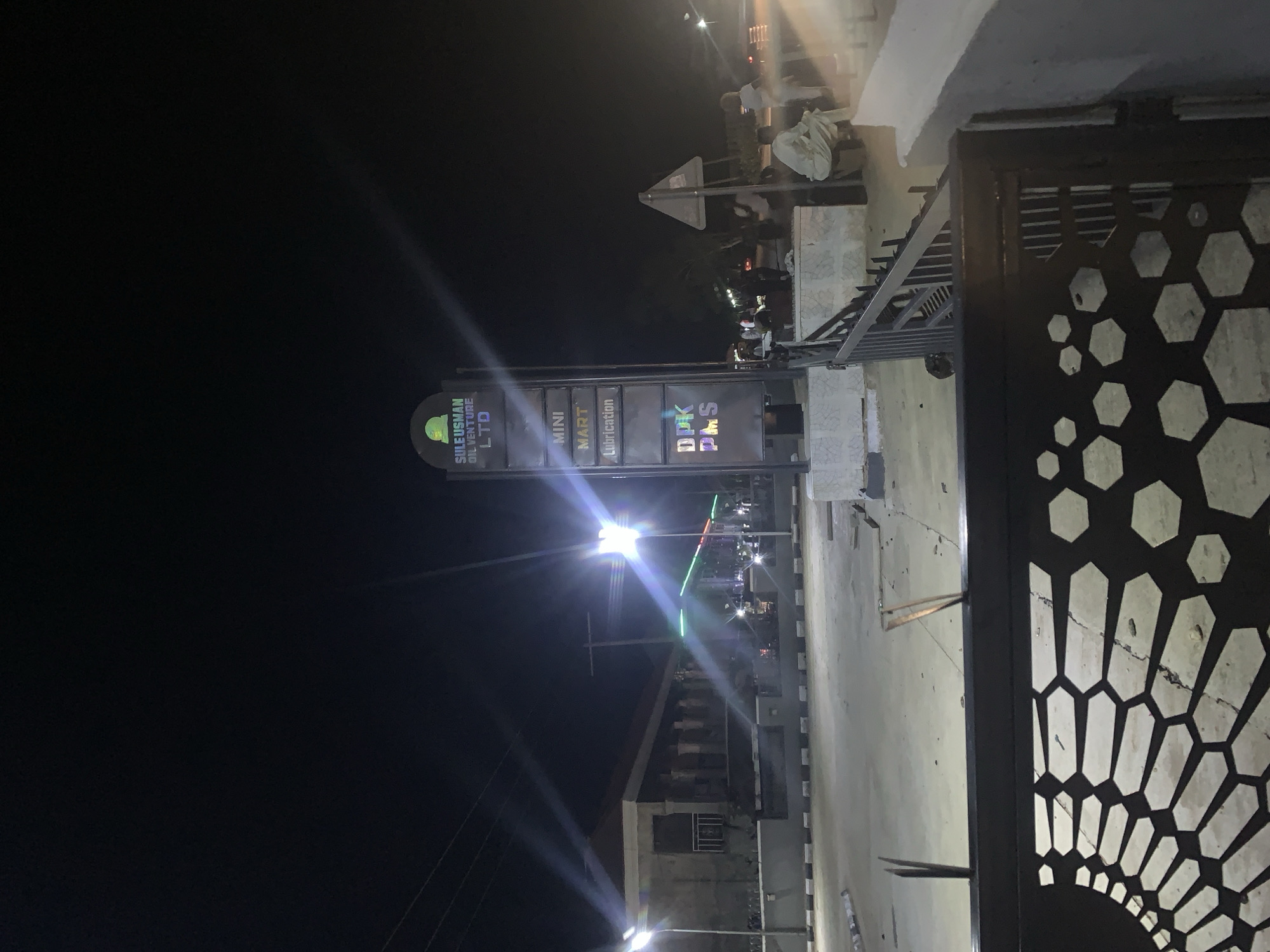 Nighttime Jalingo streets, neon signs, and printed reading material