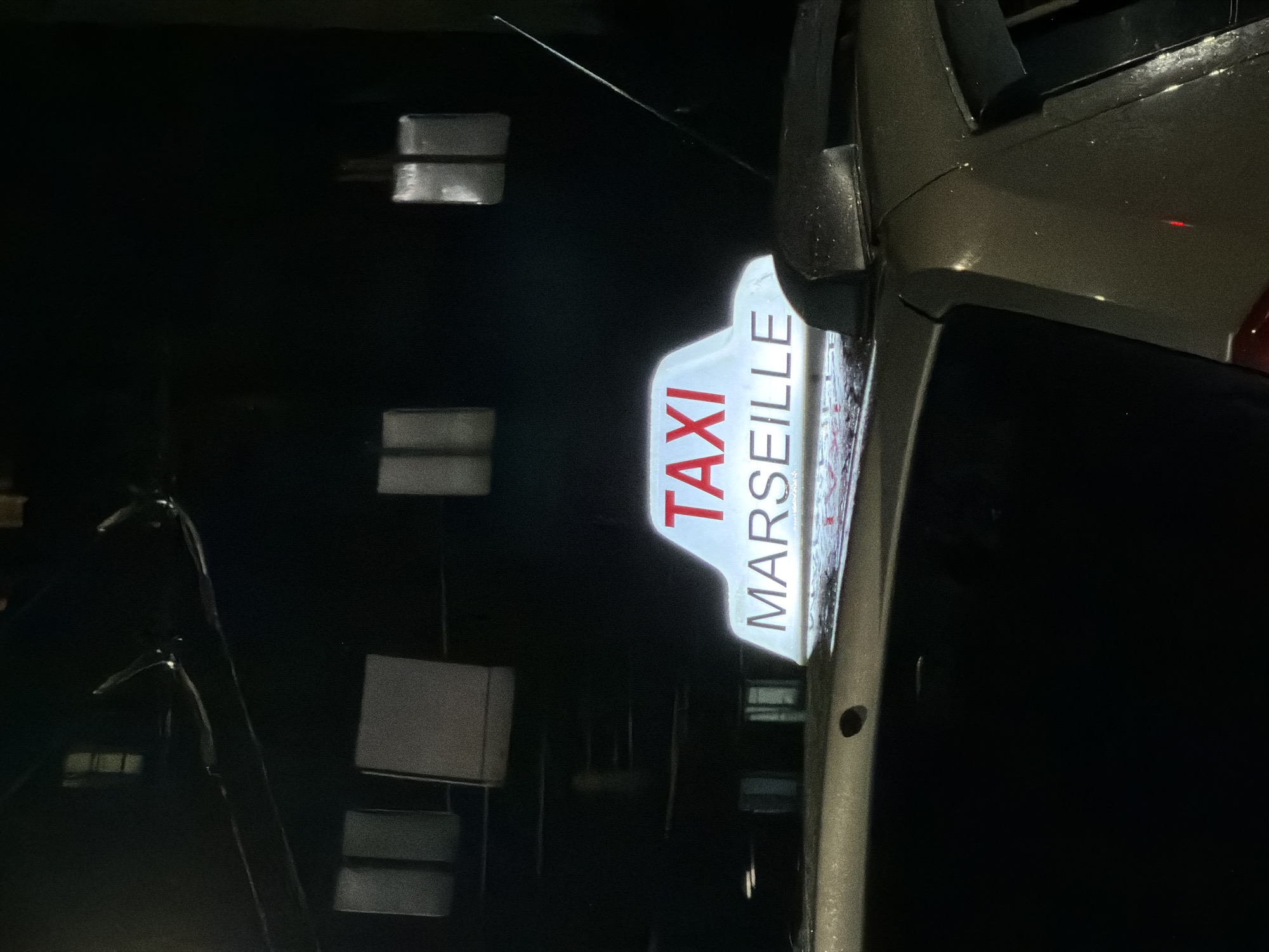 Illuminated taxi sign outside a building in Izhevsk at night