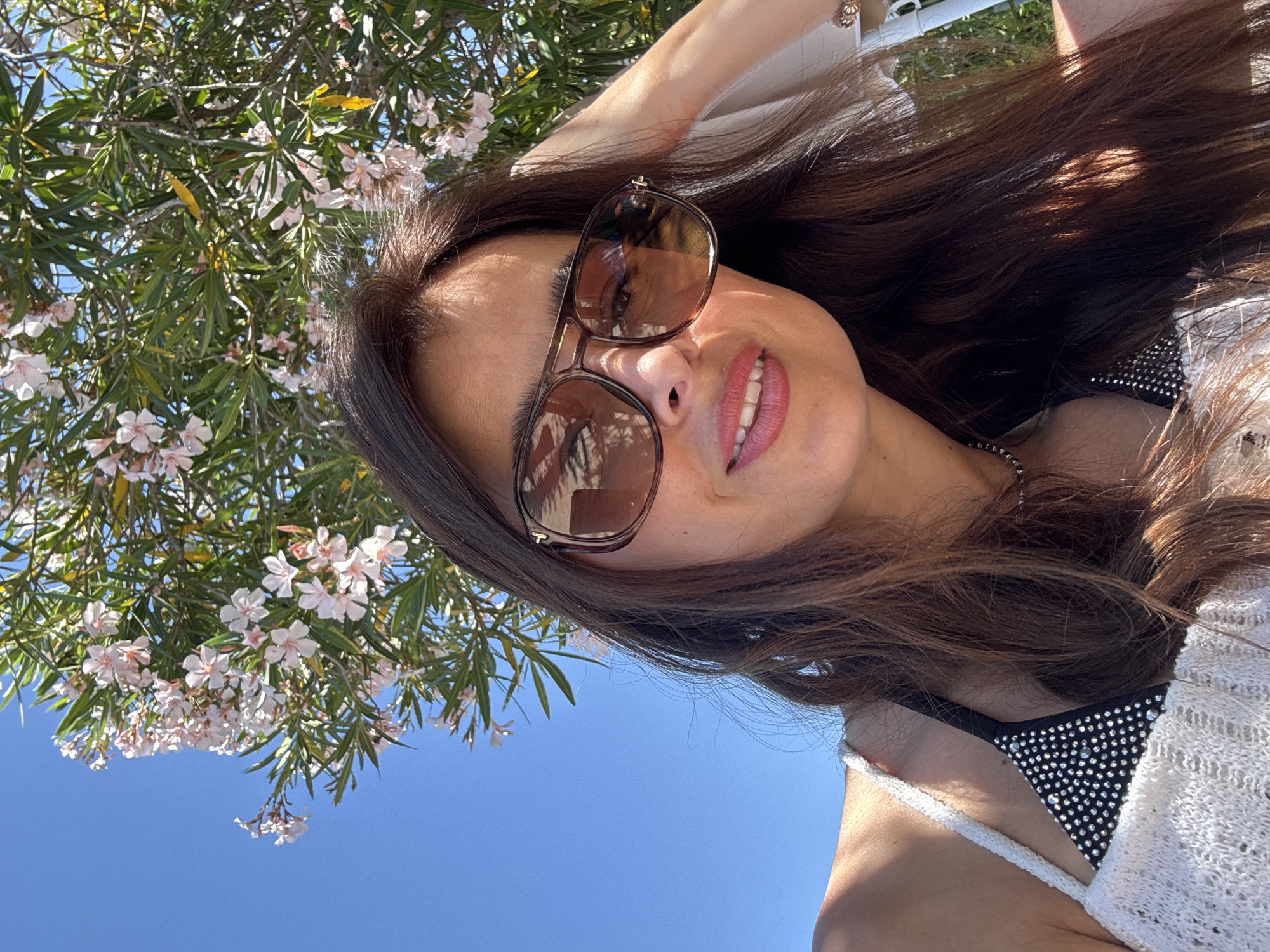 Woman enjoys sunny morning at coastal location, takes selfies