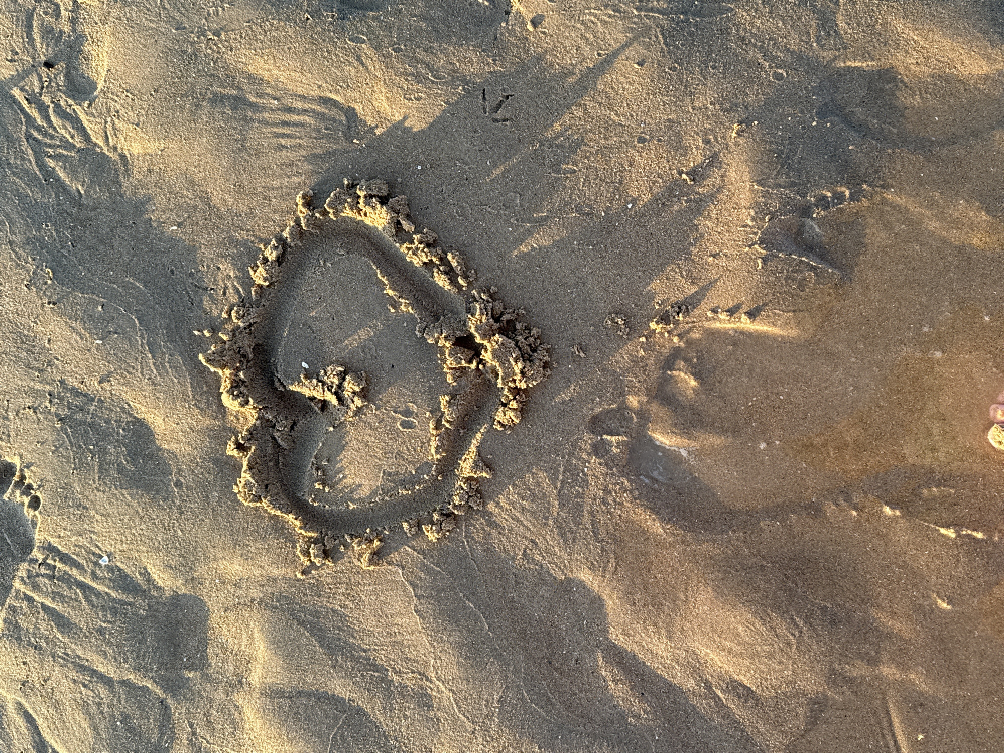 Golden hour at Cascais beach, sand art and seagulls at sunset