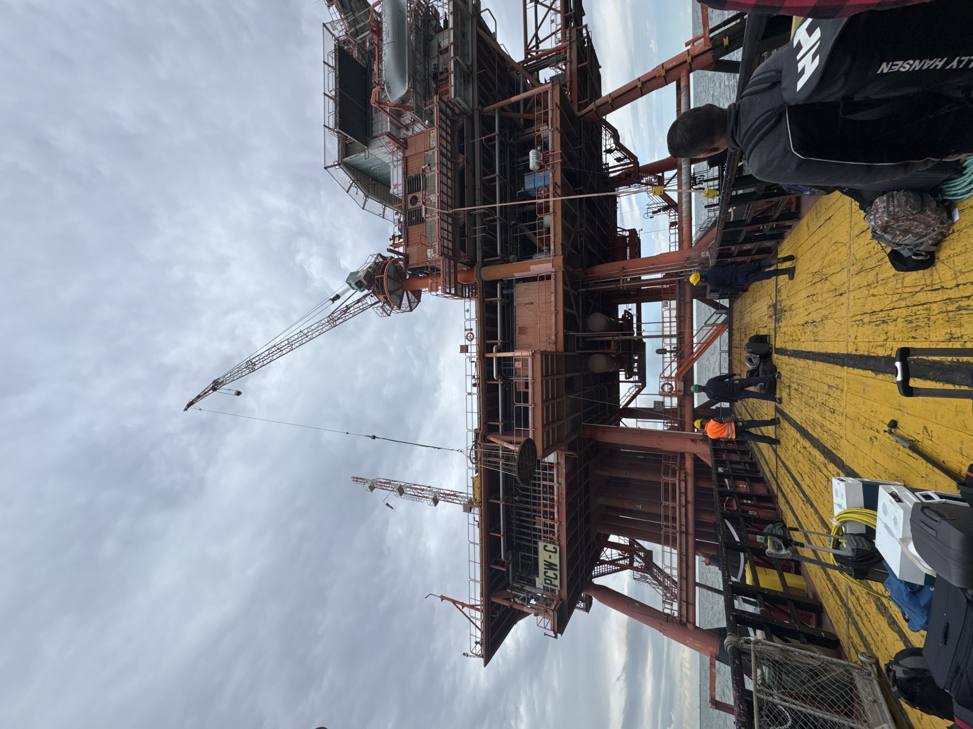 Workers observe offshore platform from supply vessel near Ravenna