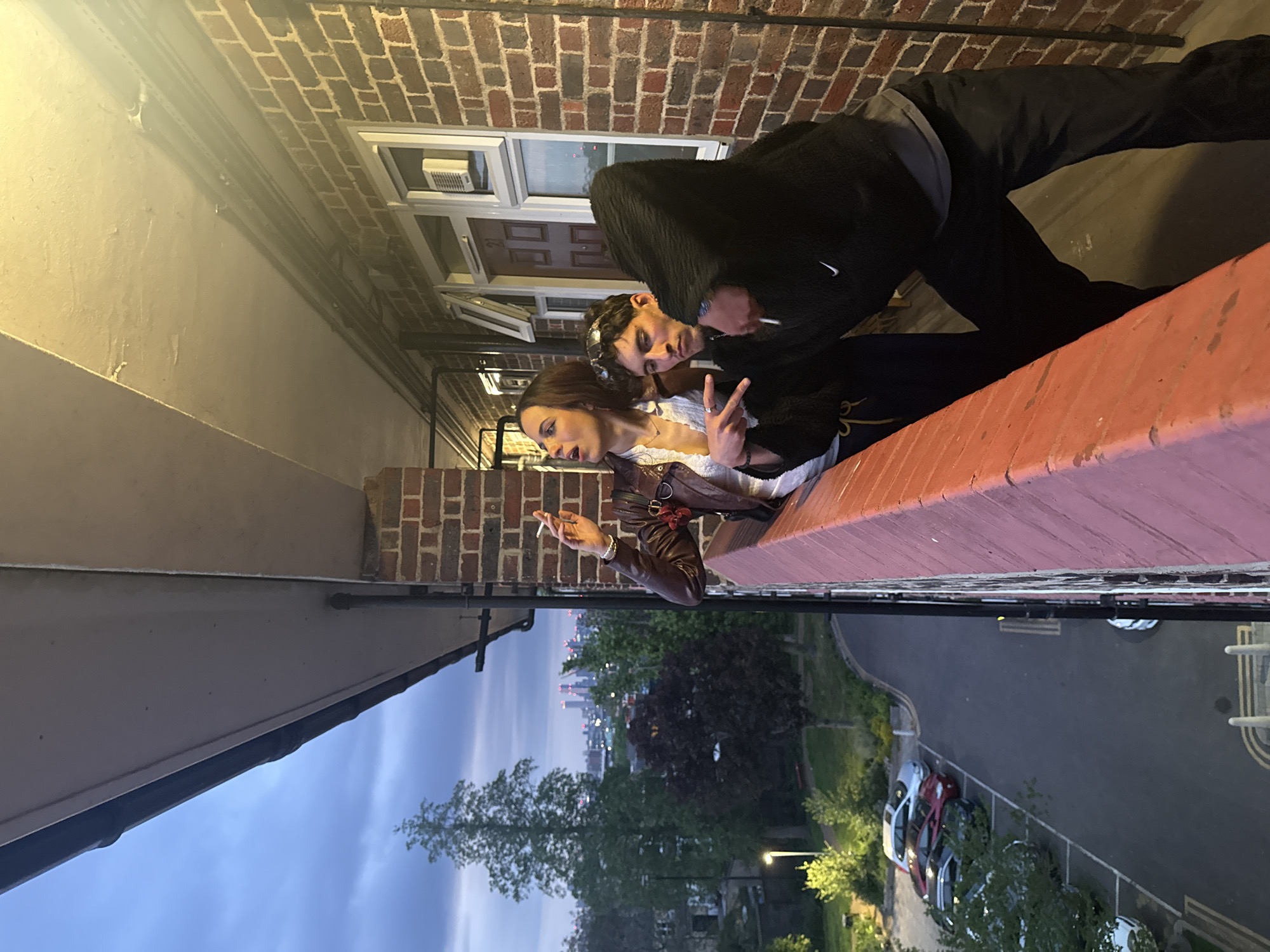 Two people share quiet moment on London balcony at dusk