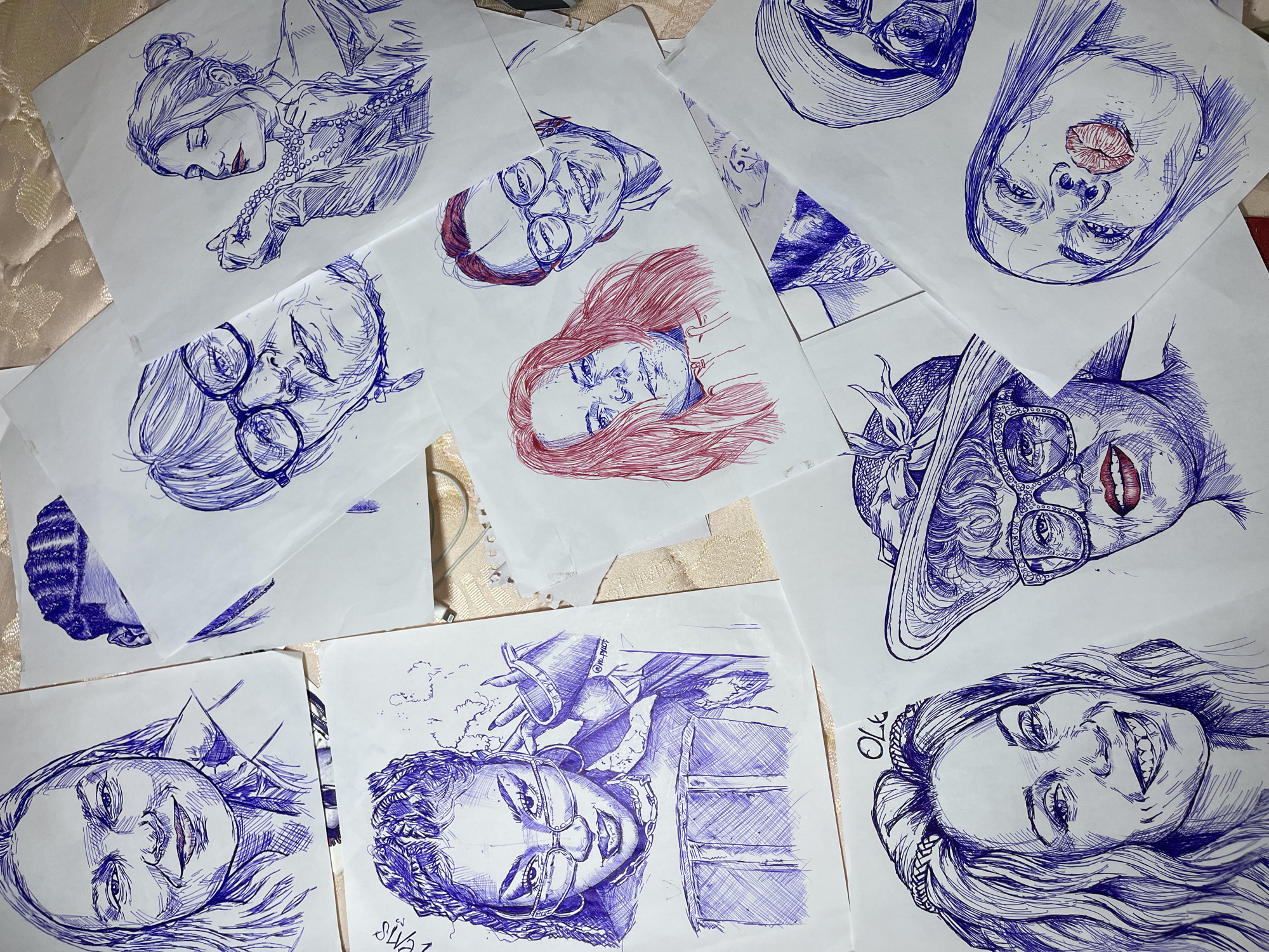 Pen-and-ink portrait sketches displayed across surfaces in Jos