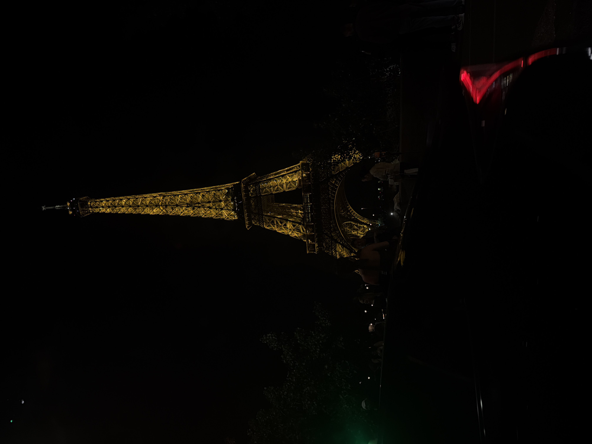 Eiffel Tower glows golden against night sky in Paris