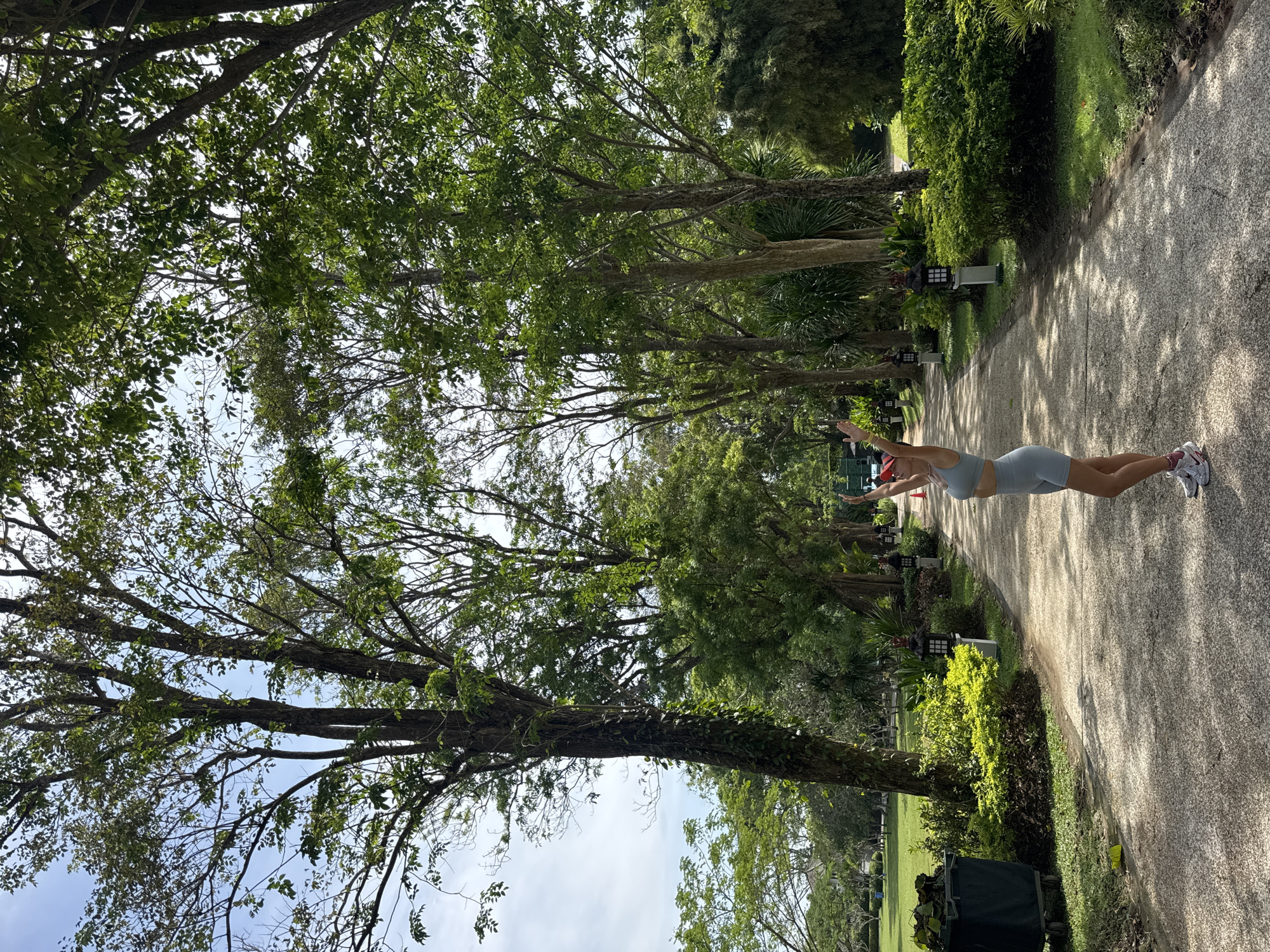 Groundskeeper maintains tropical lawn in early morning Kuta Selatan