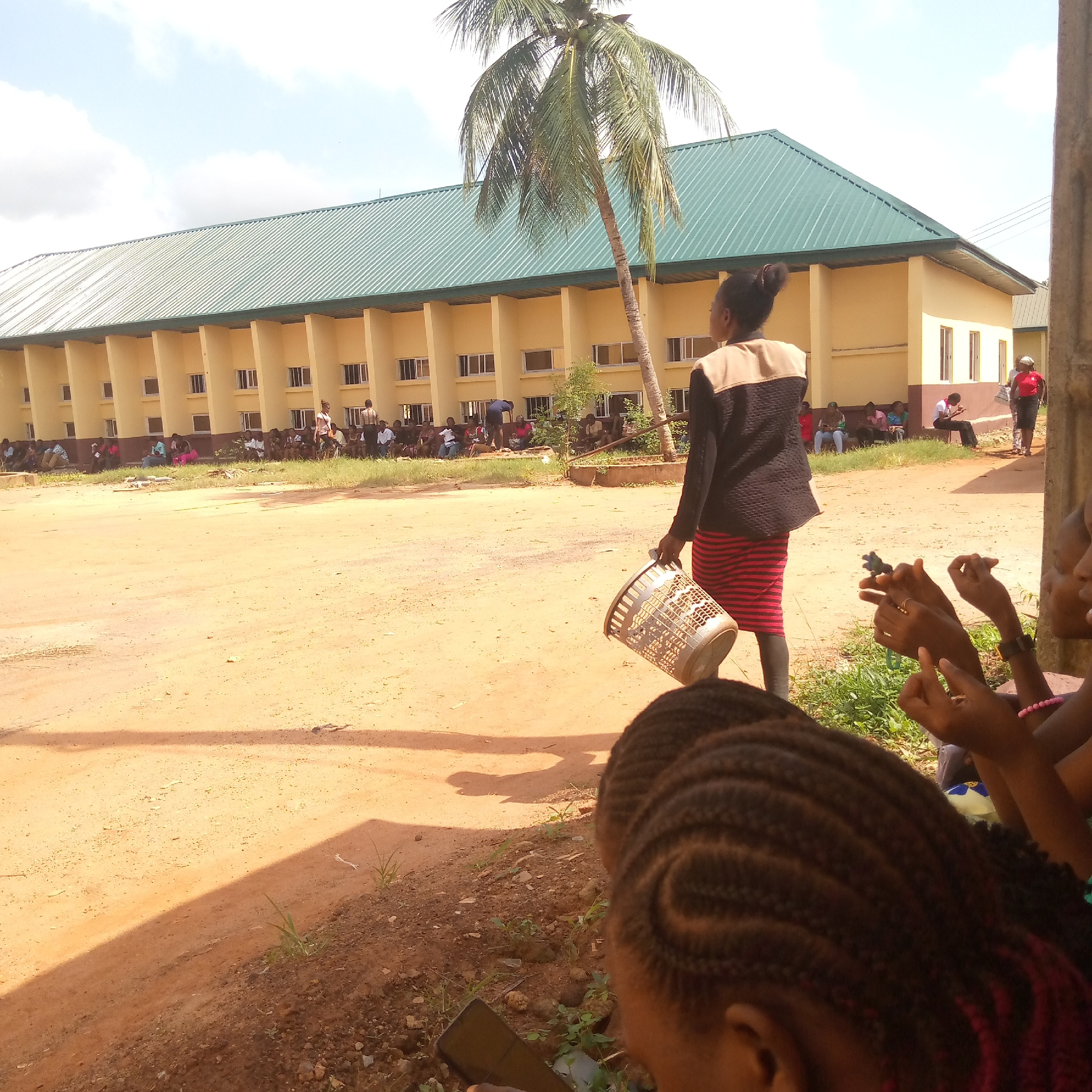 Women use smartphones outdoors near school in Ukwu-Abwa, Nigeria
