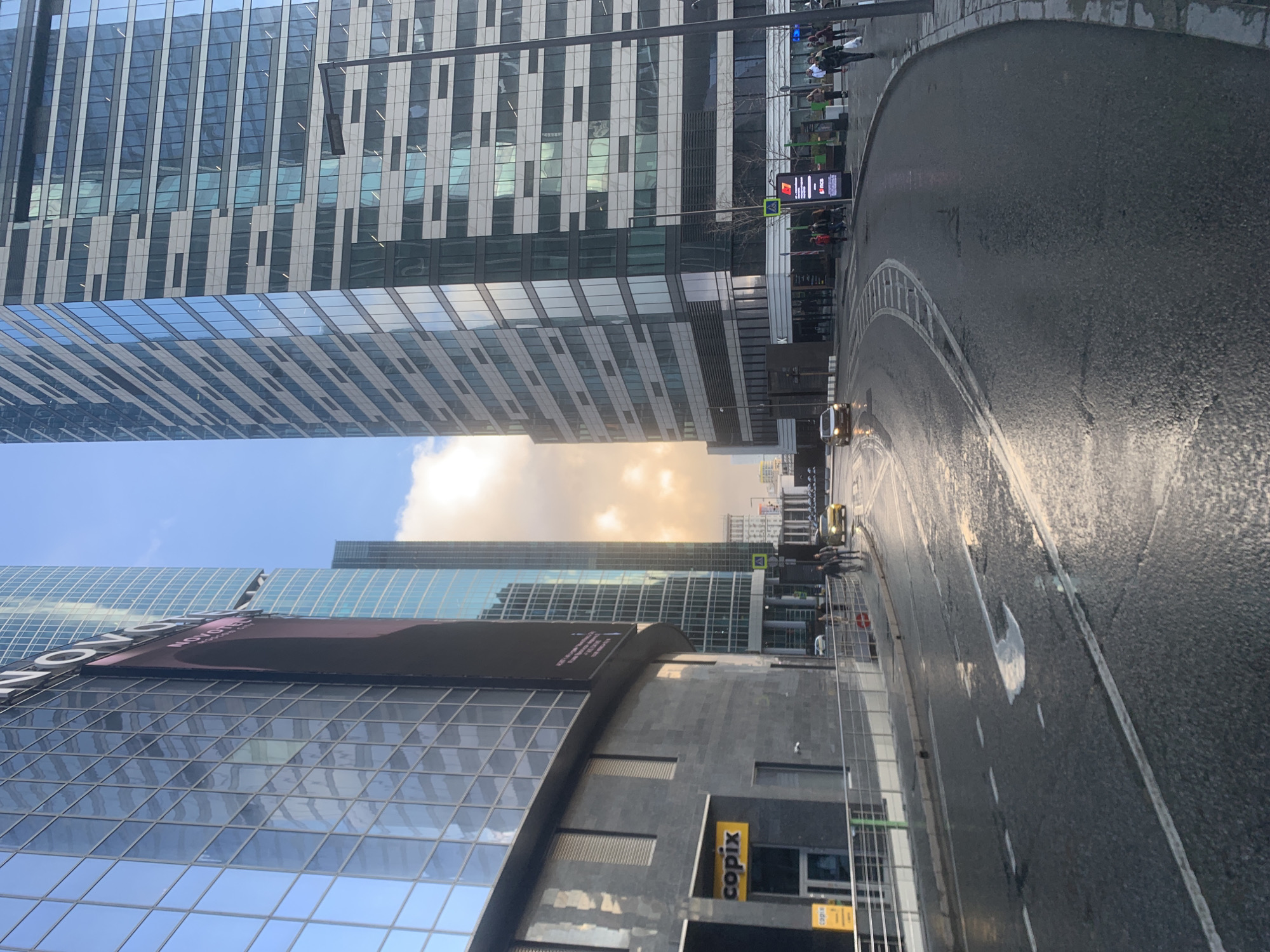 Man takes selfie on wet Khimki street amid skyscrapers