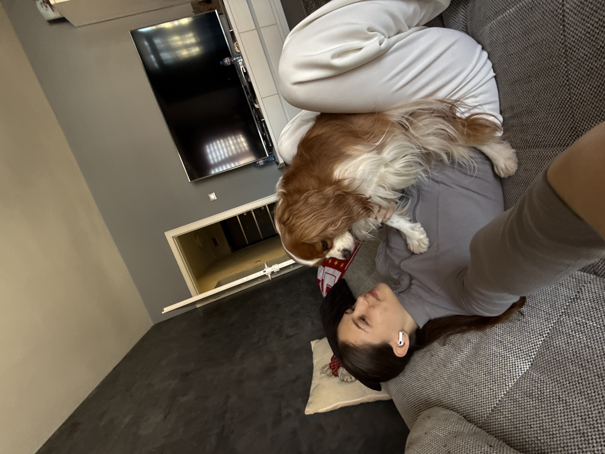 Woman relaxes with dog on sofa in Sofia home