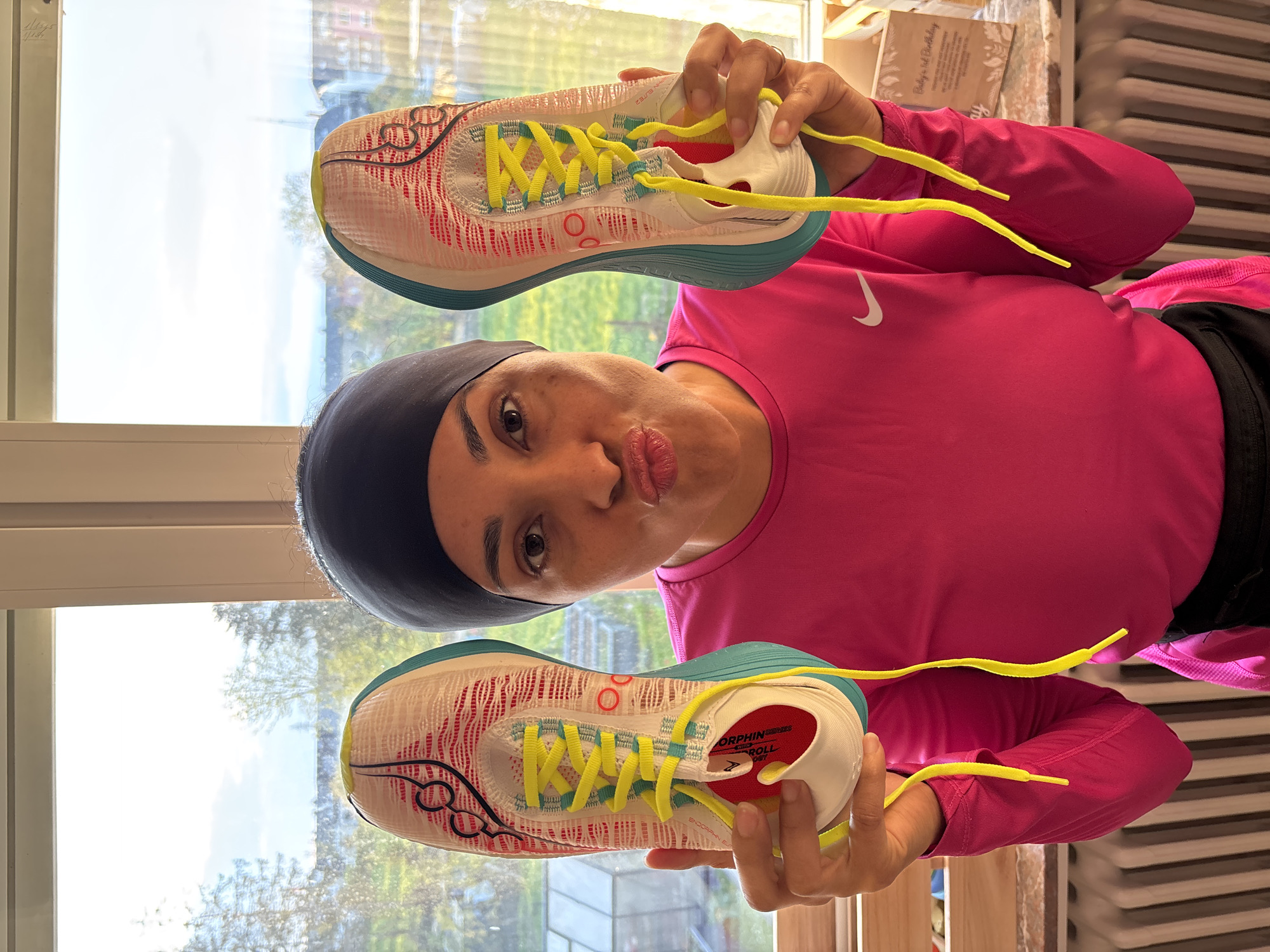 Woman playfully poses with running shoes in Luxembourg home