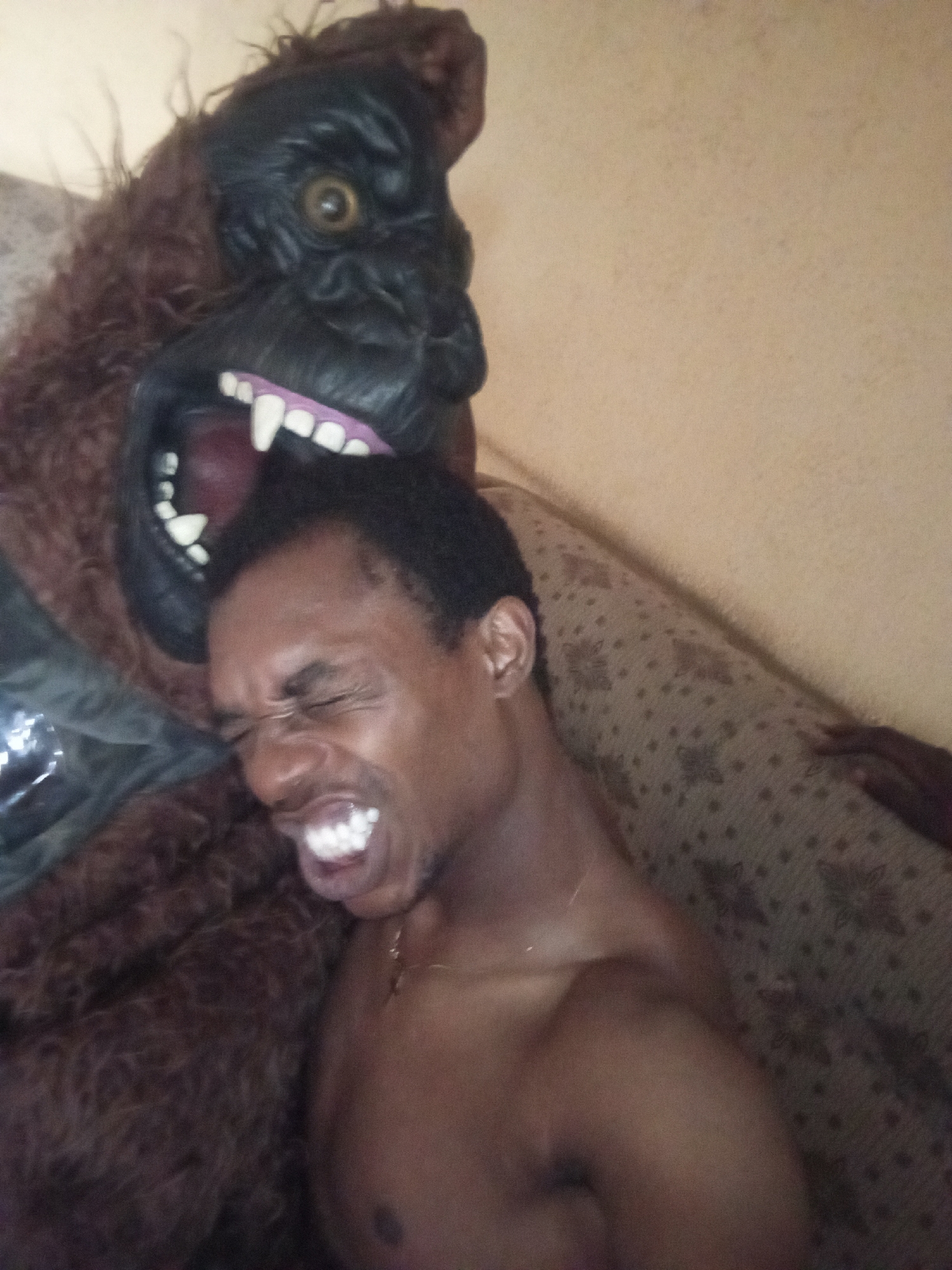 Man plays with gorilla mask indoors