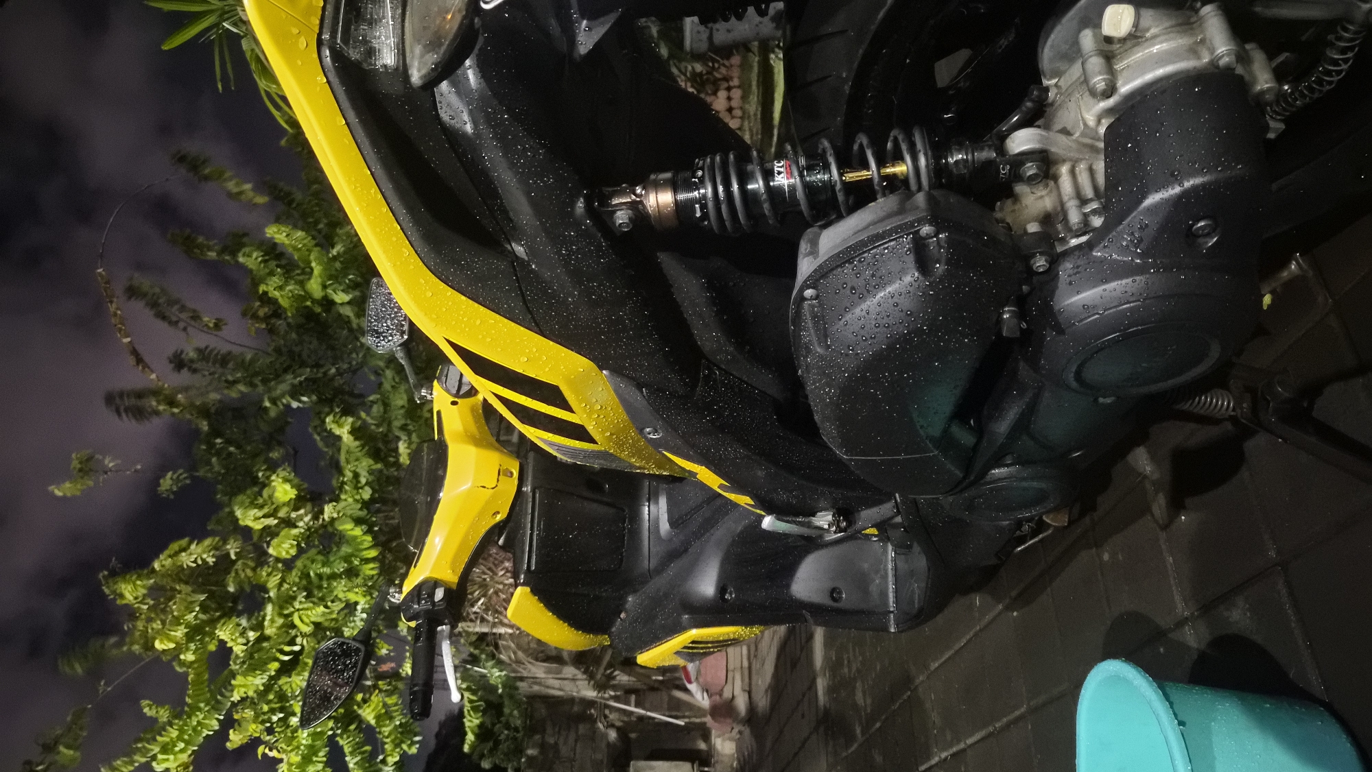Rain-soaked scooter parked on a wet Kuta night