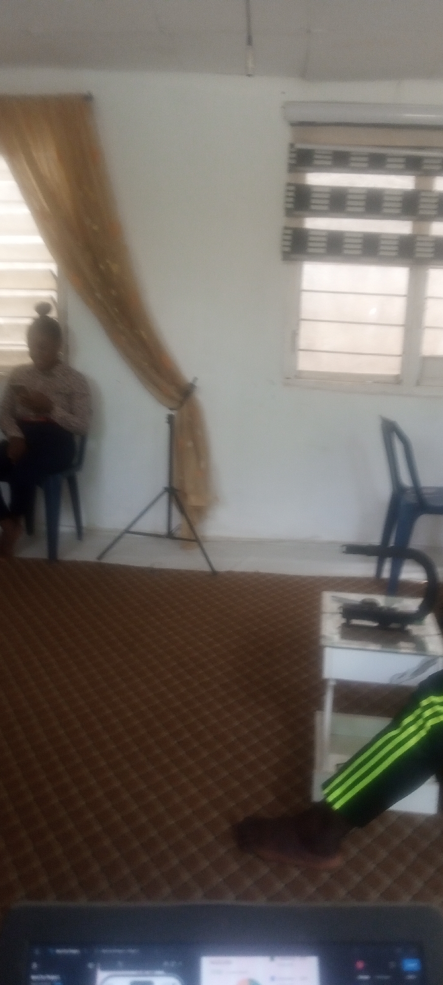 Person sits by window in carpeted room, Rido Nigeria