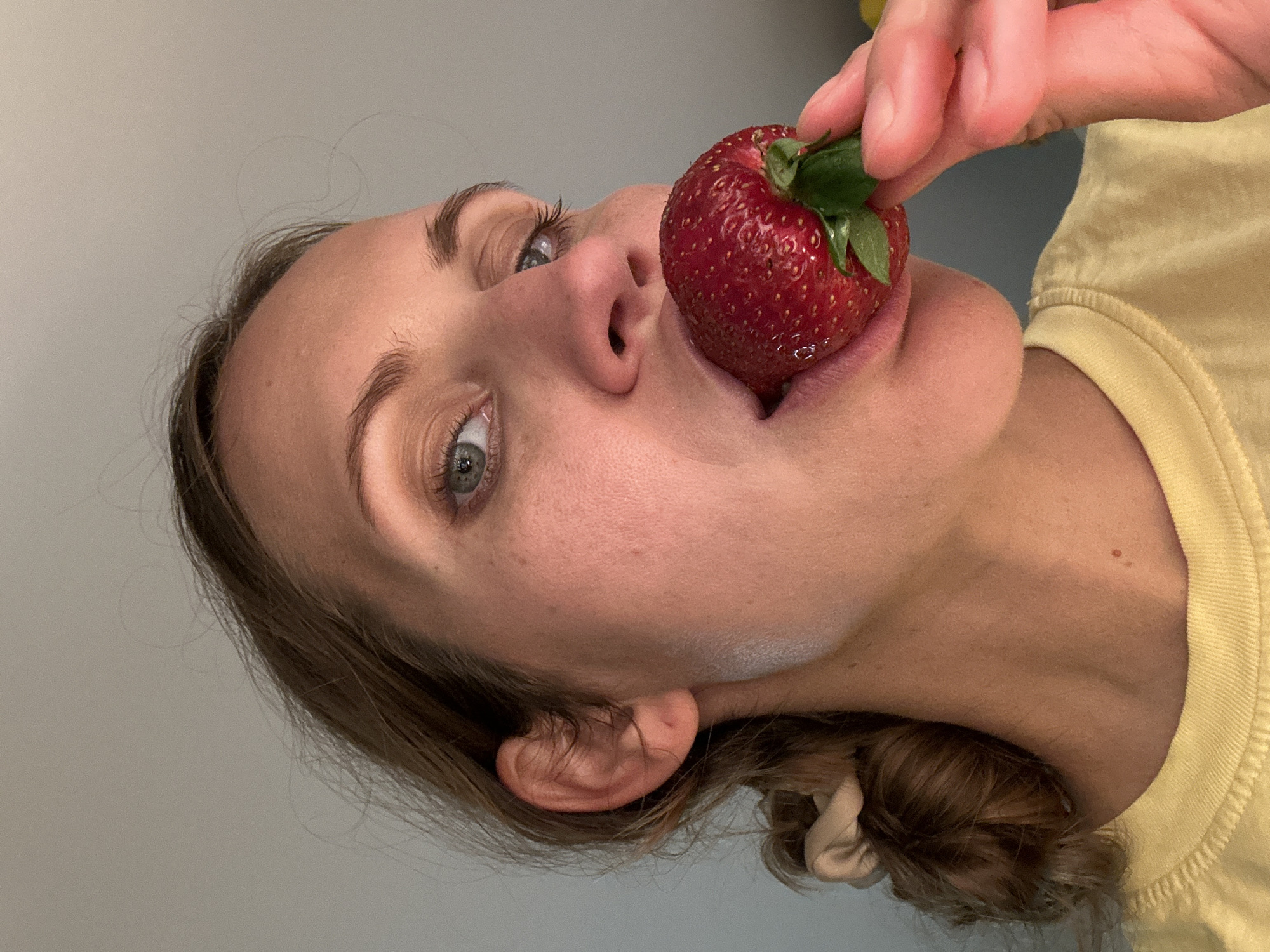 Woman enjoys large strawberry in Fethiye, Turkey