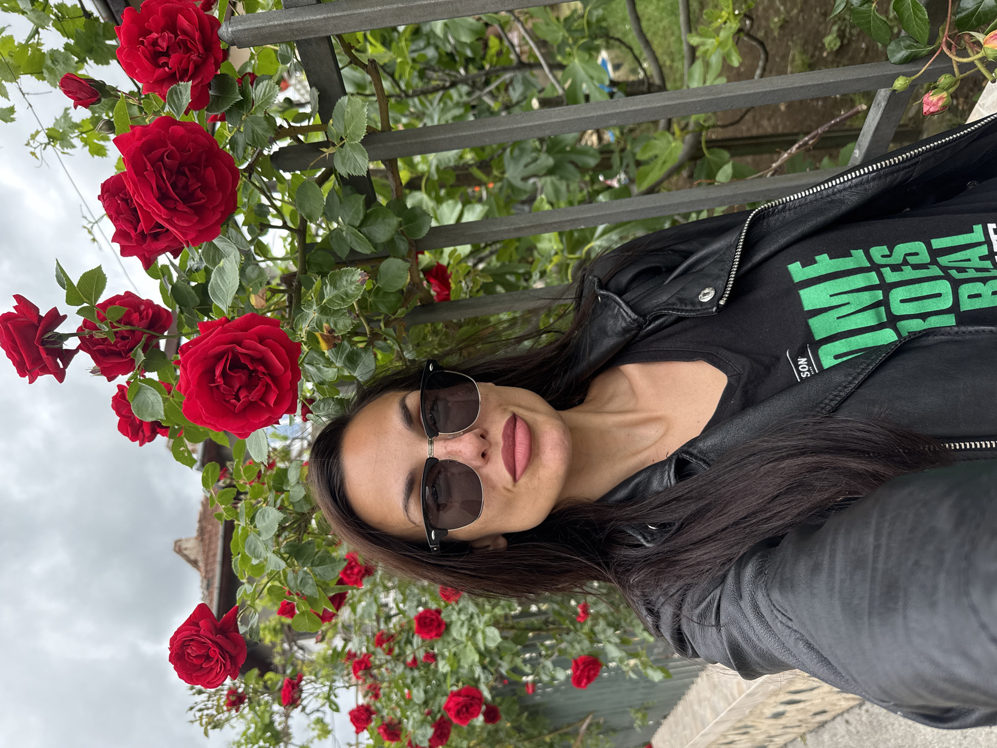 Woman poses with blooming roses in Lovech, Bulgaria