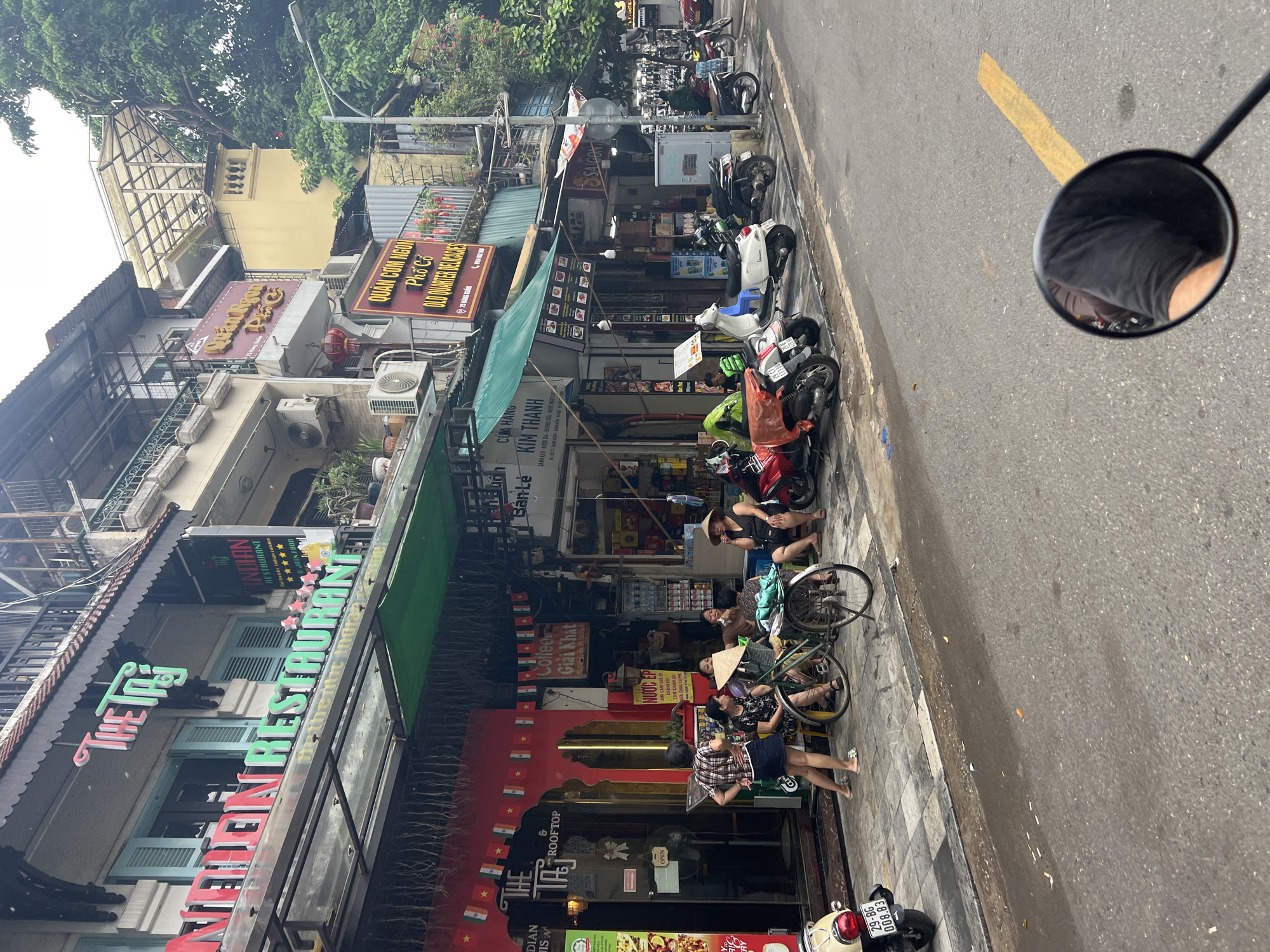 Hanoi Old Quarter street life, police truck parked on wet road
