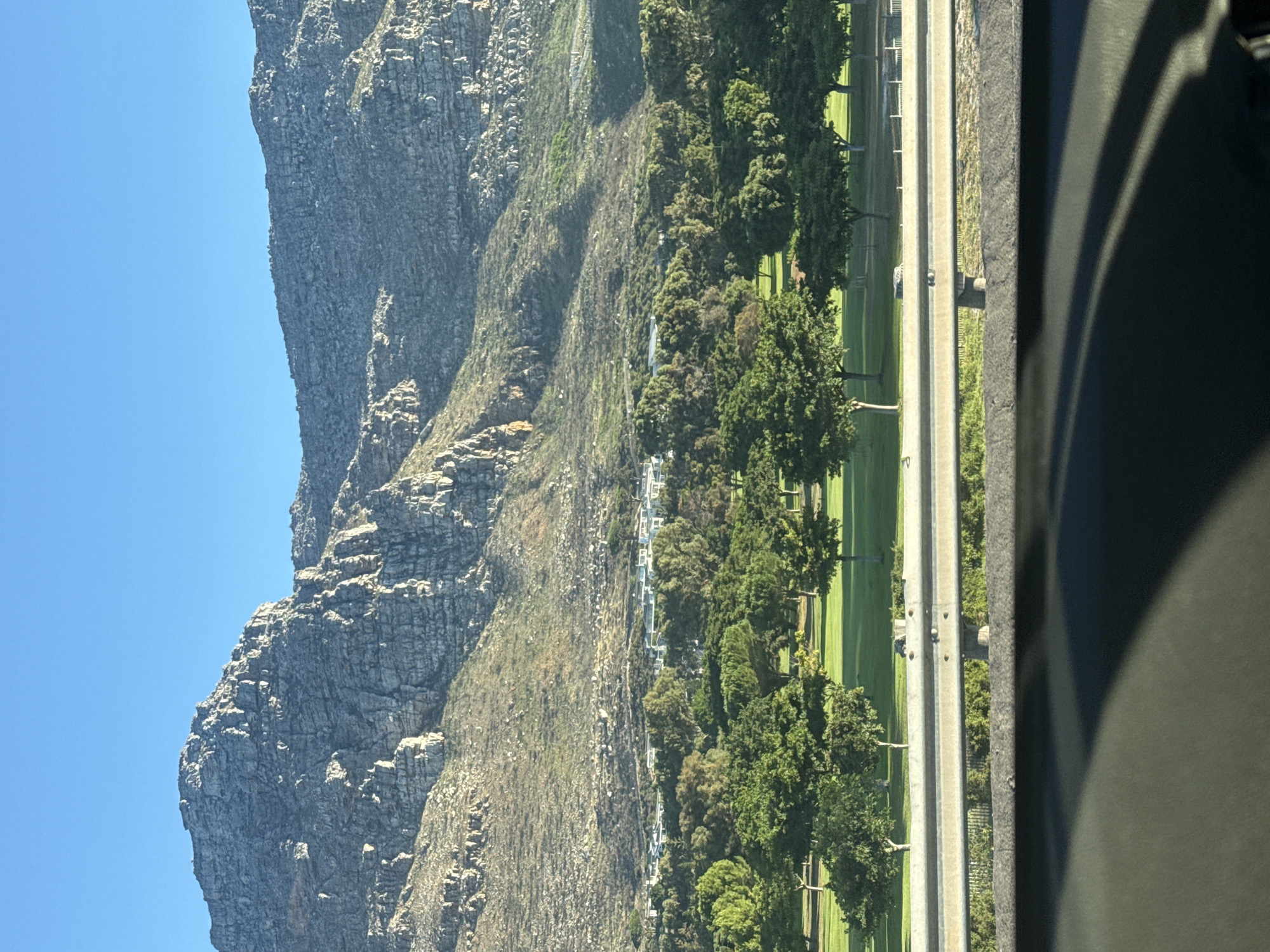 Passenger uses phone while traveling past Table Mountain, Cape Town