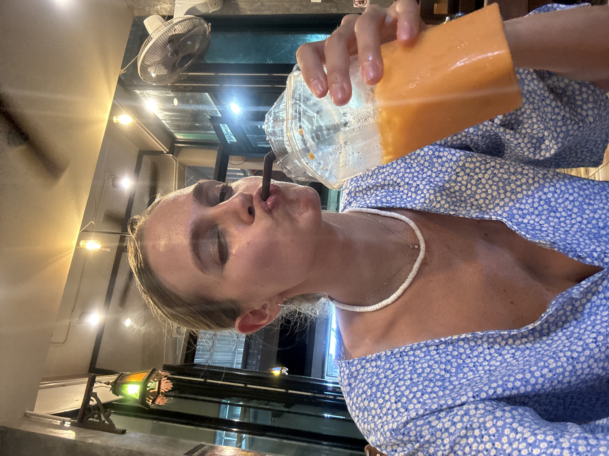 Woman enjoys orange drink in Patong cafe