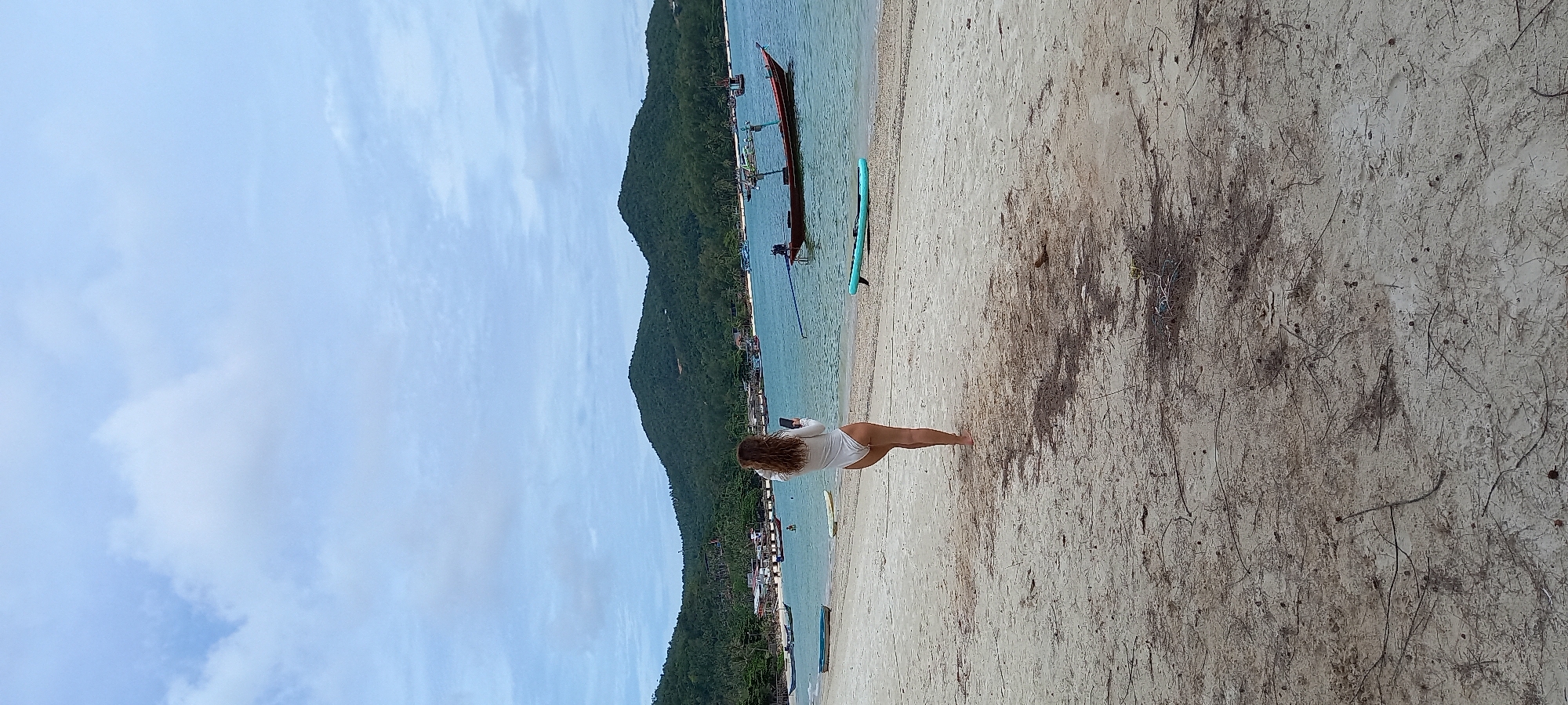 Woman with paddleboard spotted at Thai beach among boats