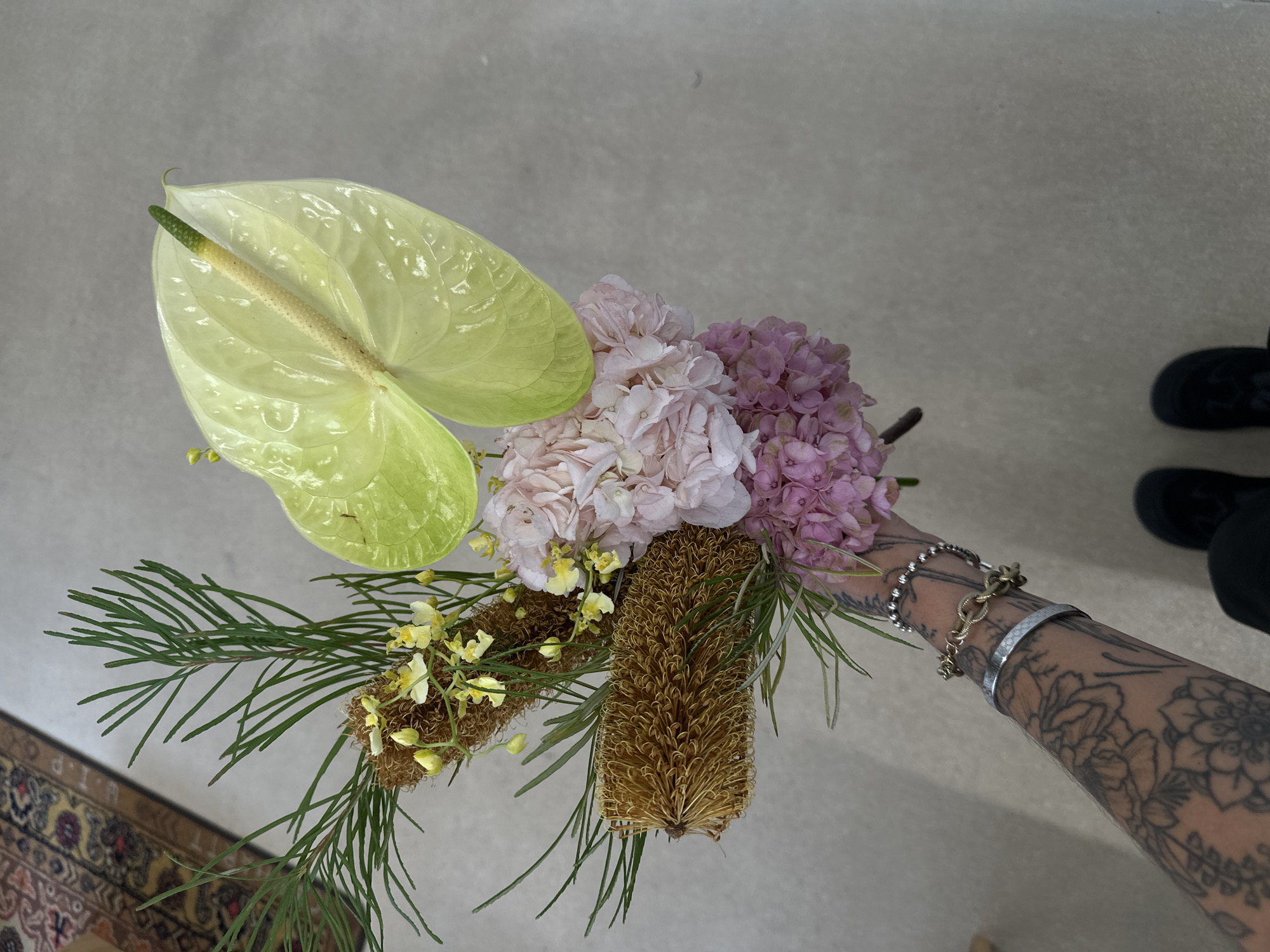 Tattooed florist arranges bouquets in Paris workspace