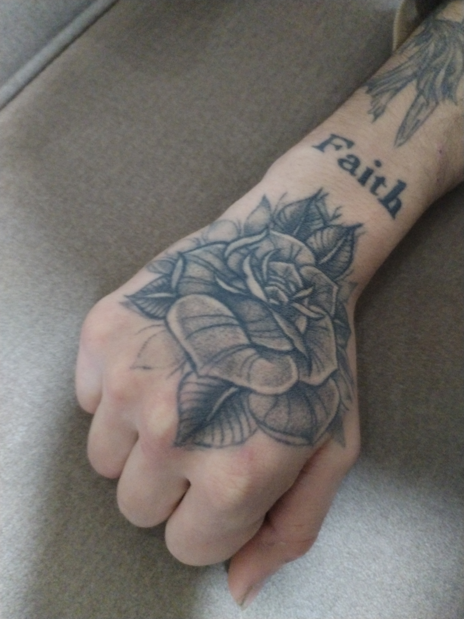 Tattooed hand and forearm displayed in Ghent