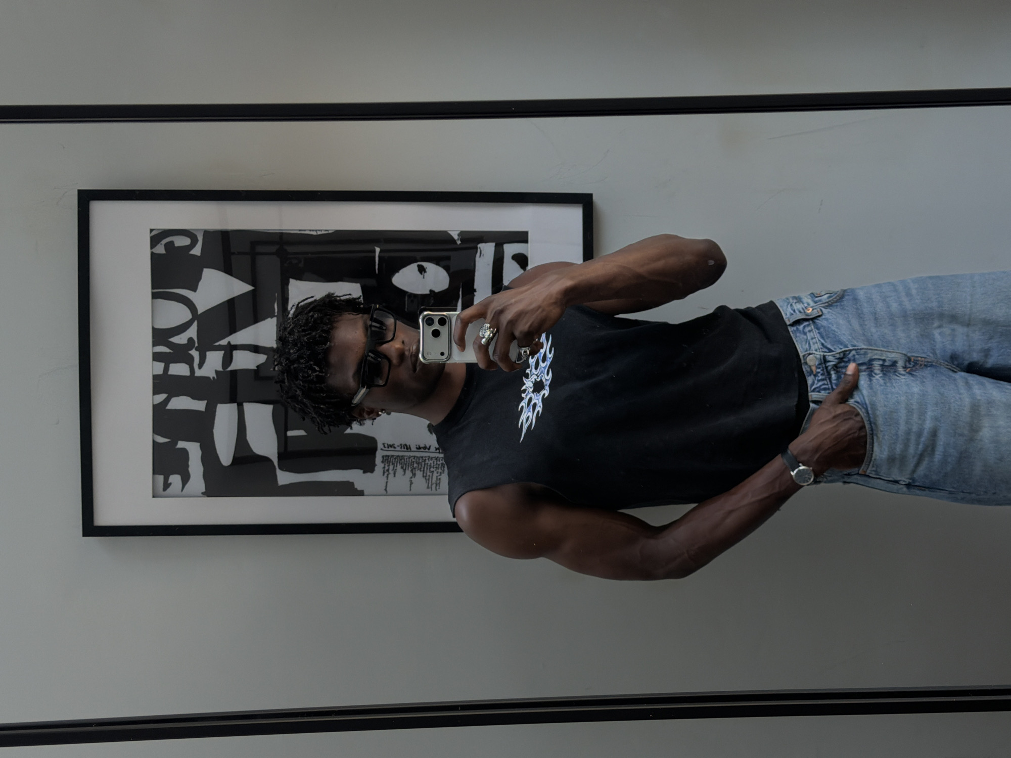Mirror selfie showing flame graphic tee and light blue denim
