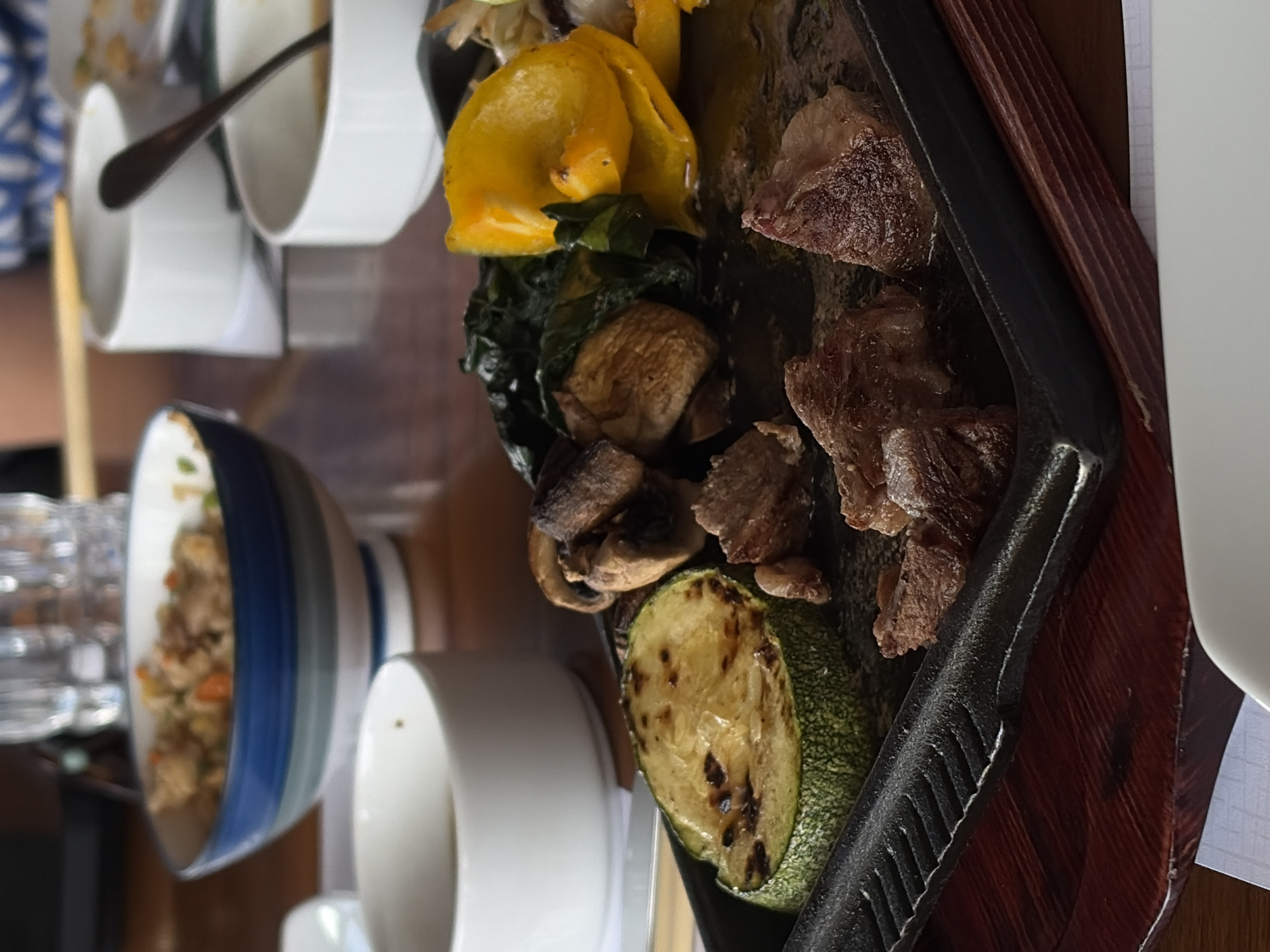 Restaurant meal documented with iron griddle, partially consumed