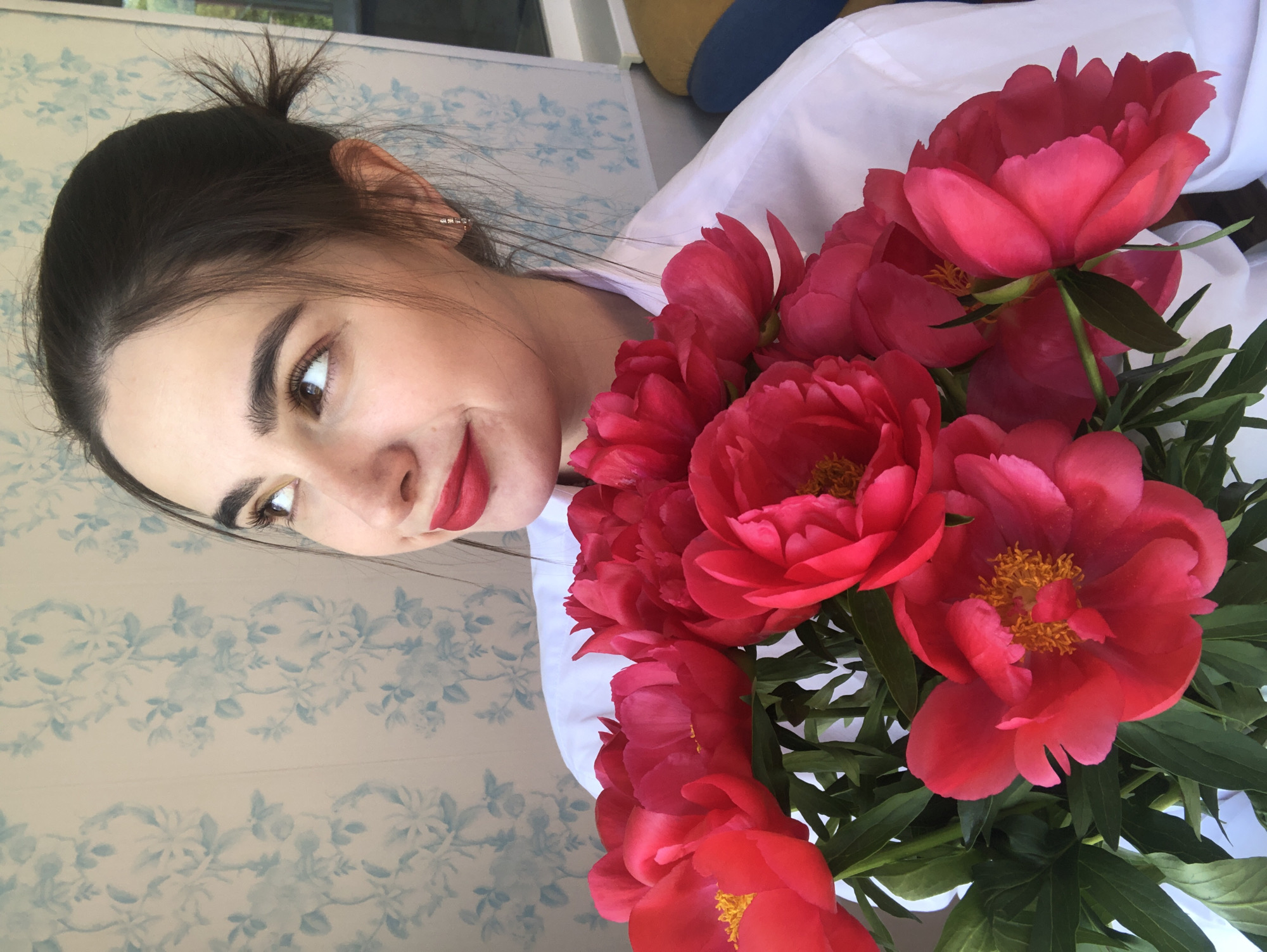 Woman photographed with pink peonies in Noviy, Russia