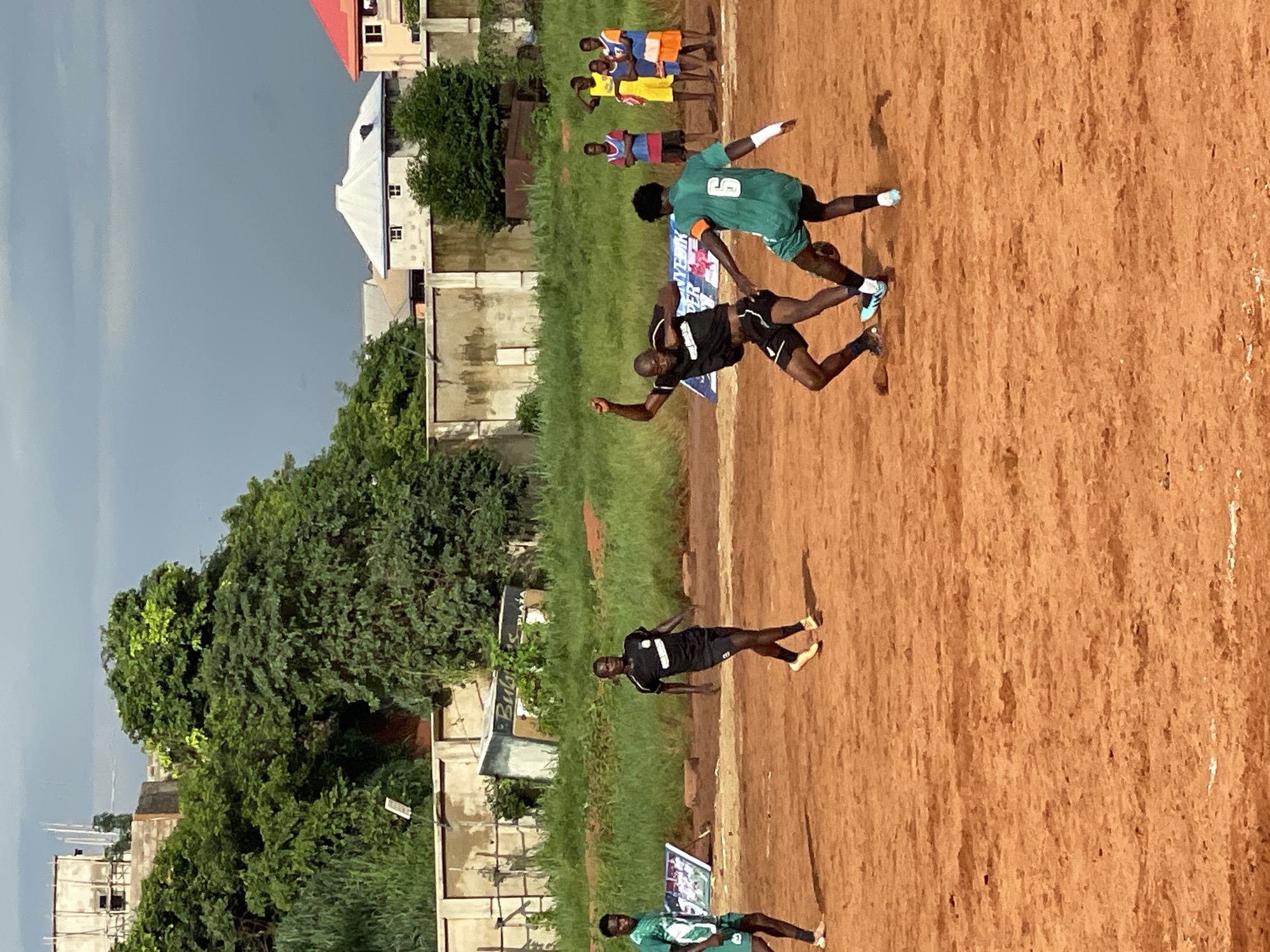 Community soccer match played on dirt field draws local spectators