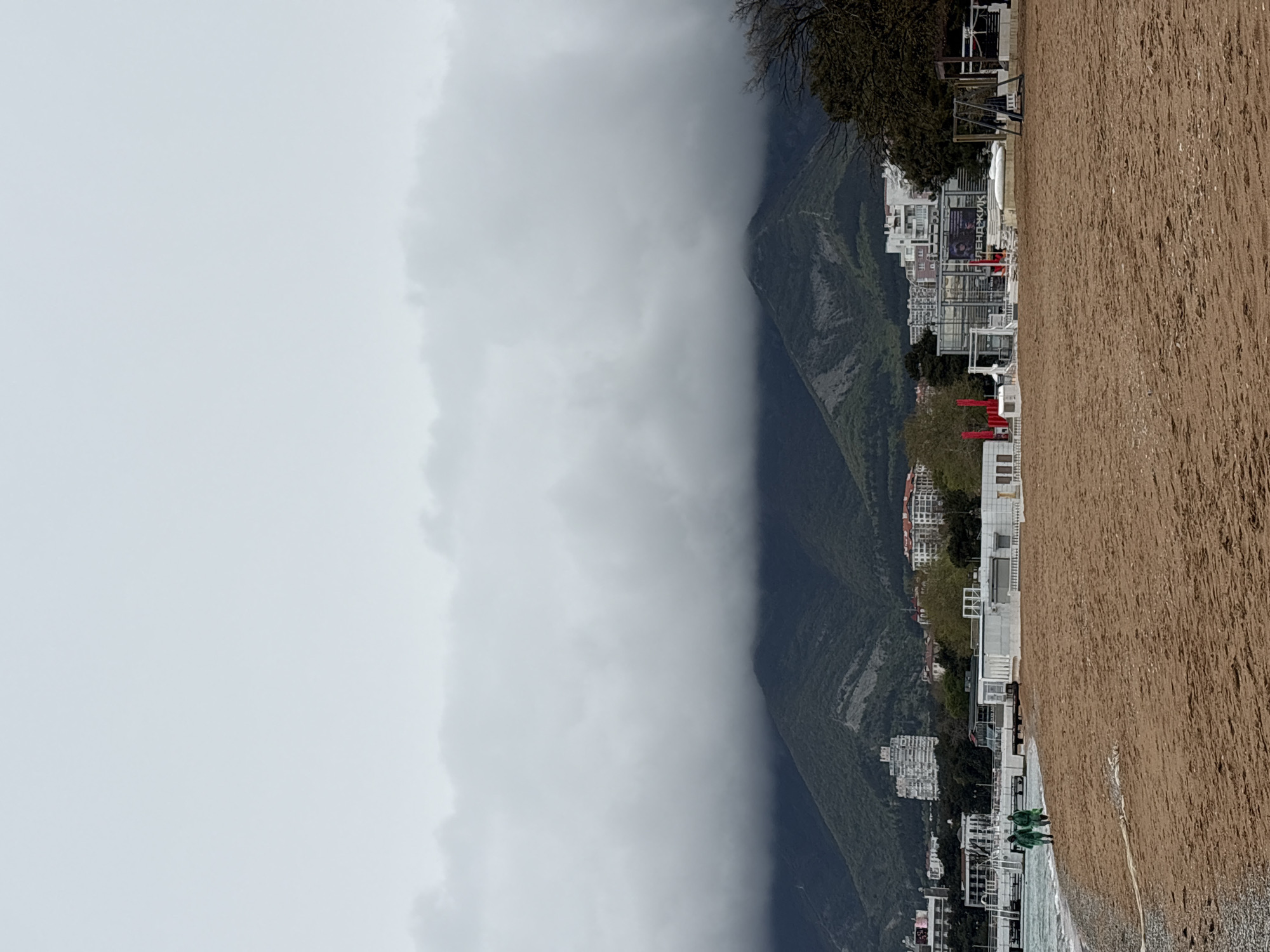 Foggy coastal landscape with beach and buildings documented