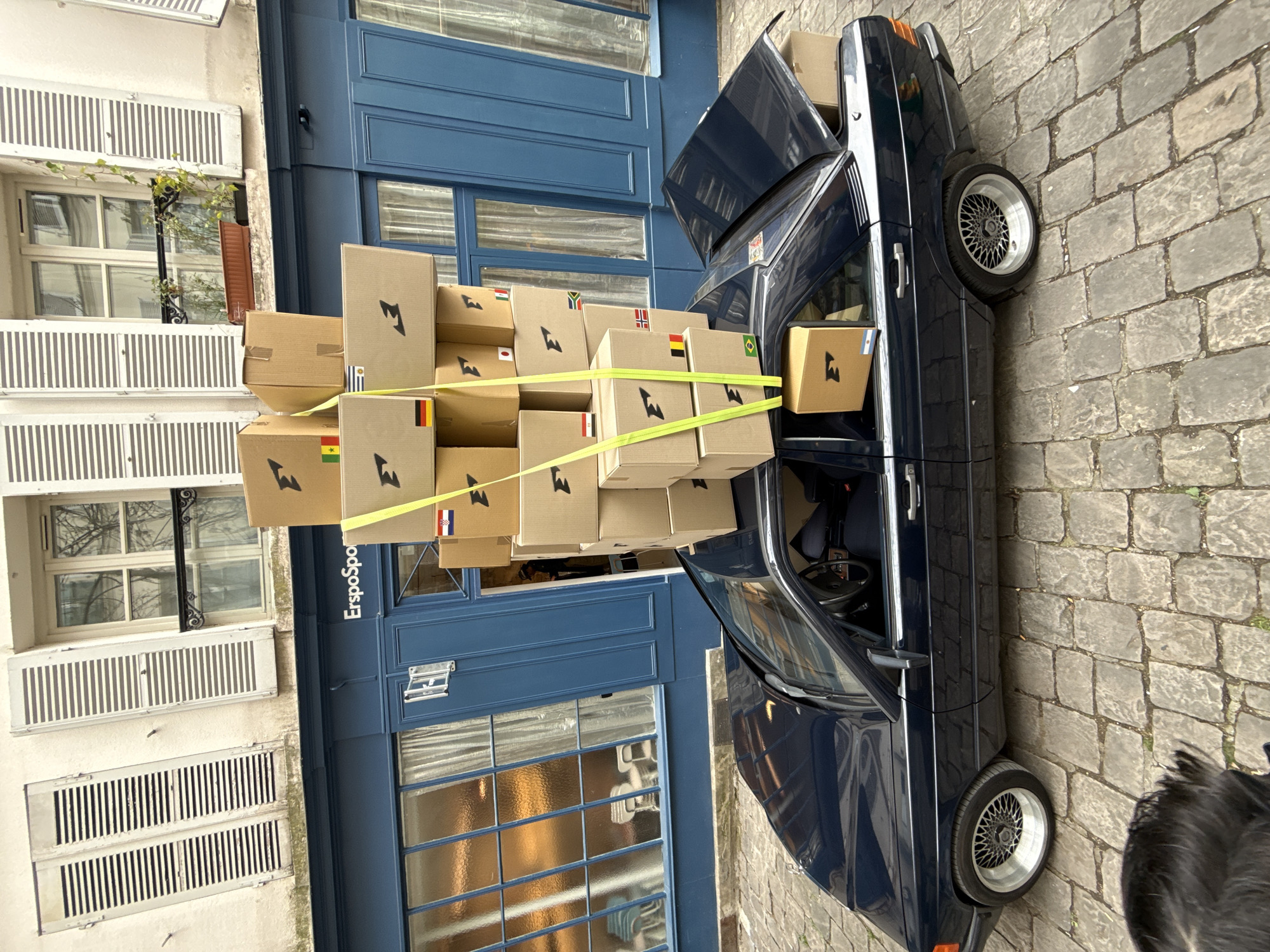 Person moves boxes with blue car in Paris
