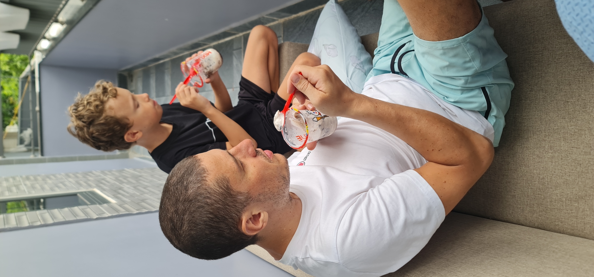 Father and child share boba tea on Đà Nẵng patio