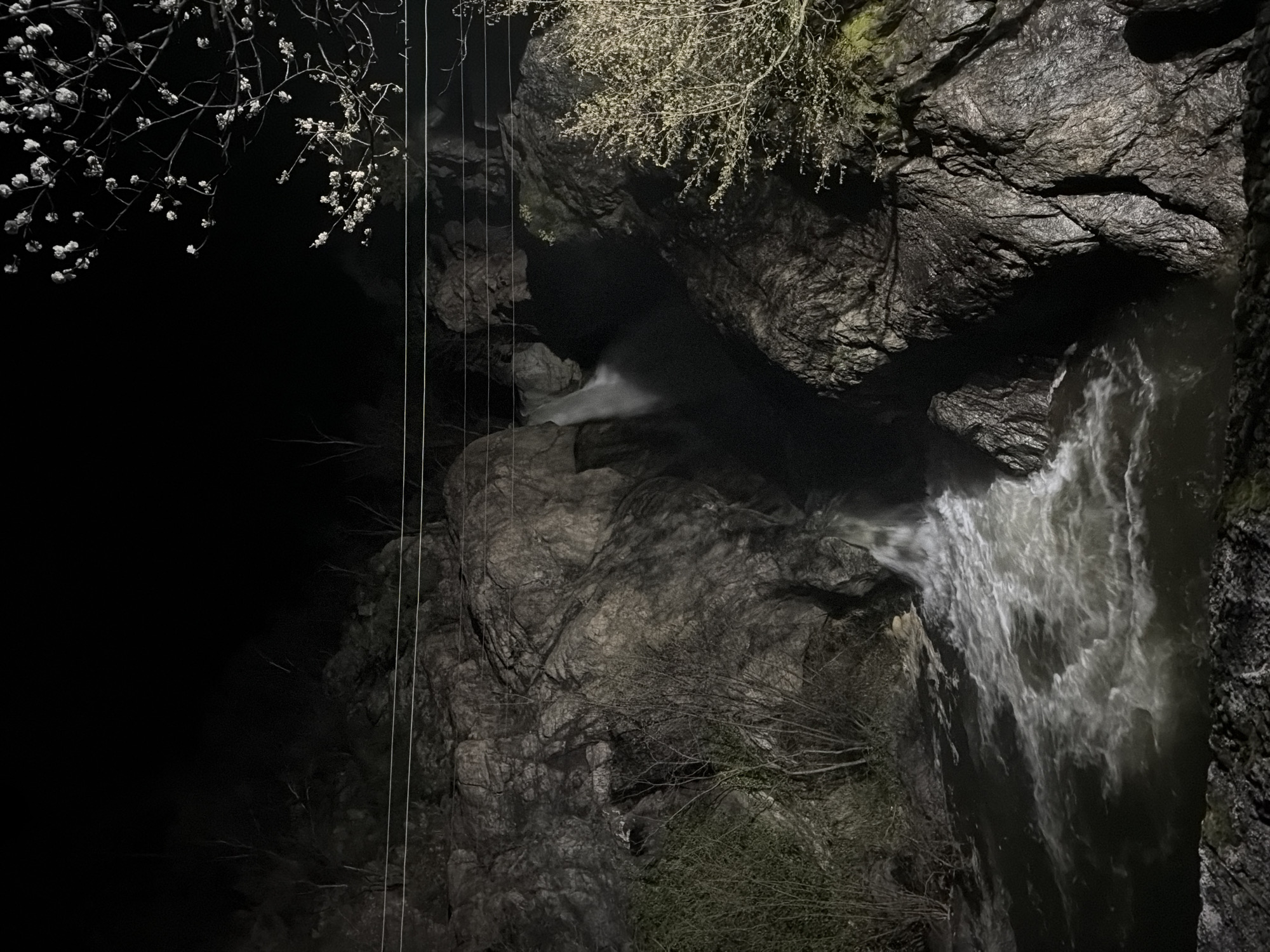 Woman photographs nighttime waterfall scene in Karlovo, Bulgaria