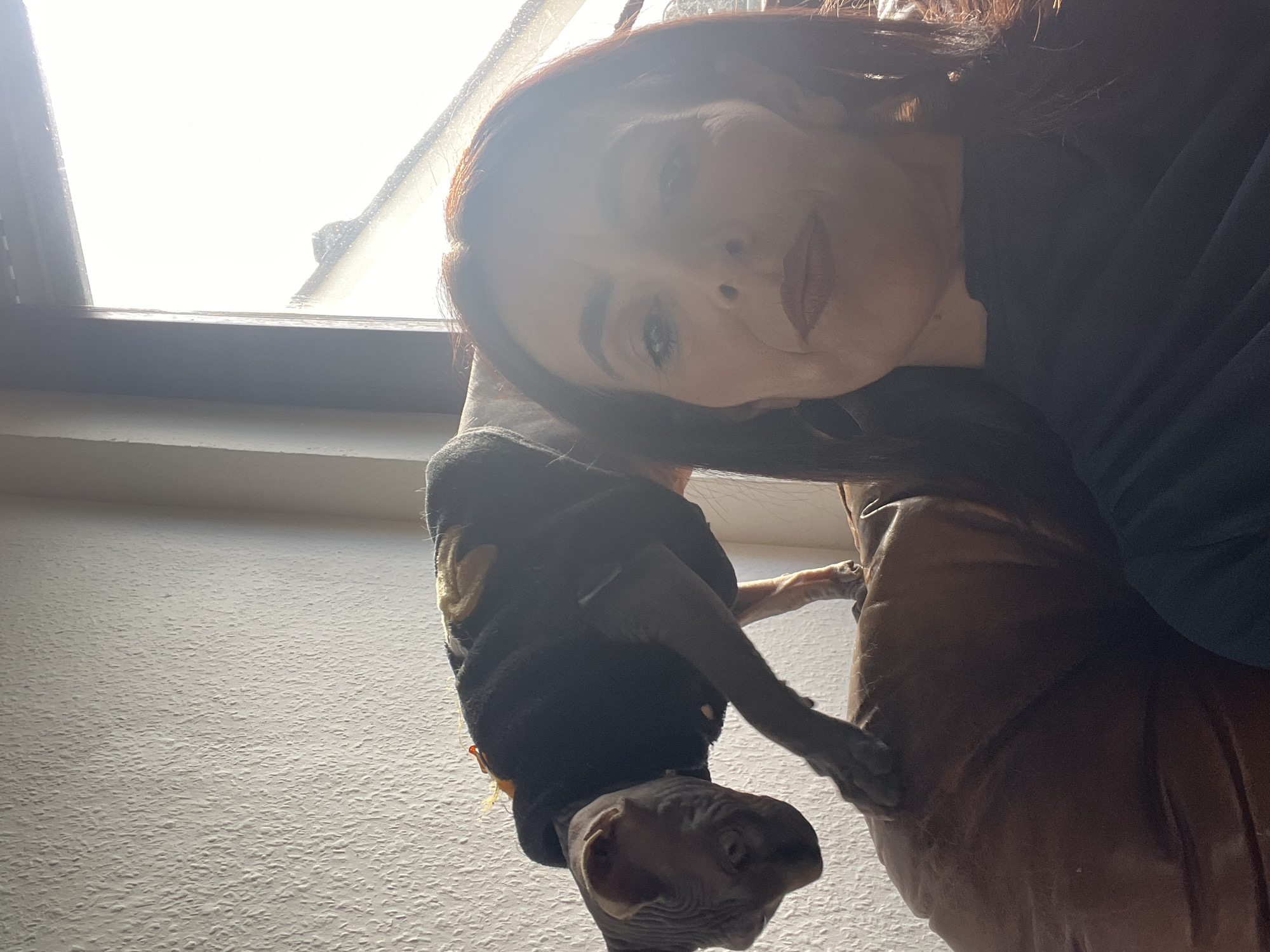 Woman enjoys quiet afternoon at home with Sphynx cat