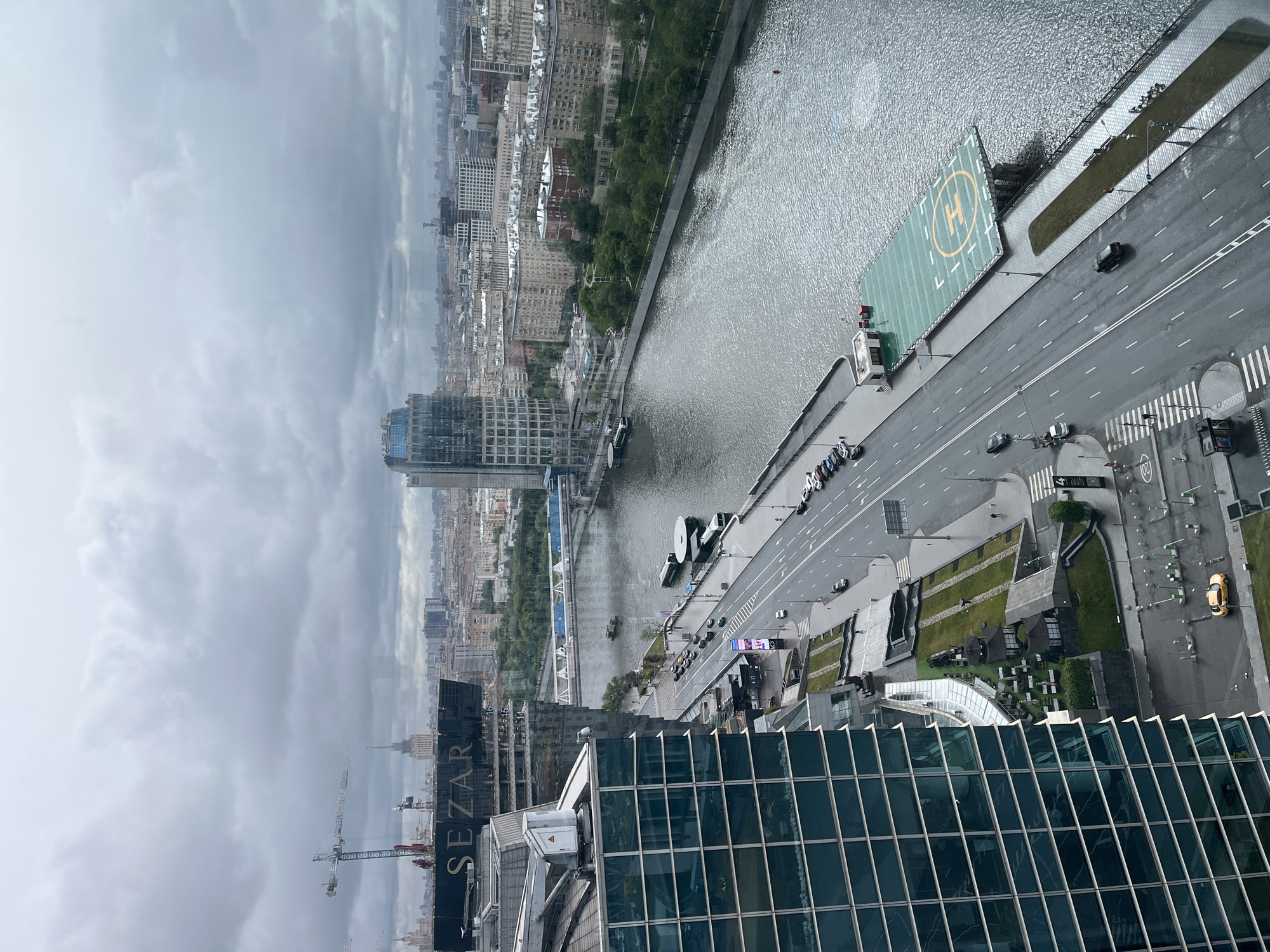 Aerial view captures overcast cityscape with river and helipad