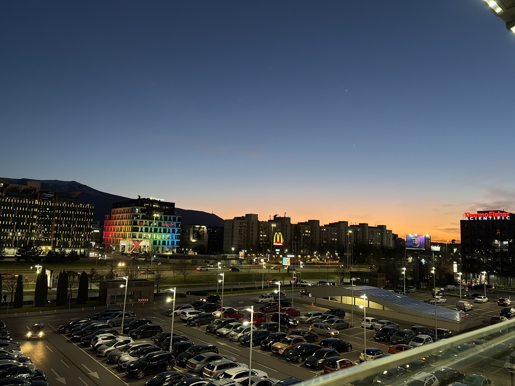 Evening parking garage view captures busy Sofia lot at dusk