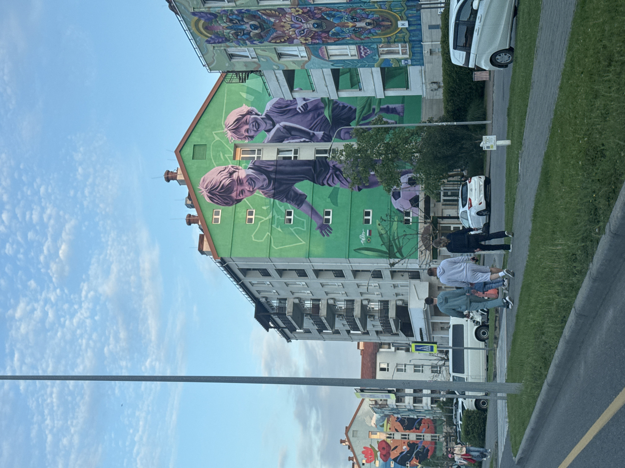 Pedestrians gather near mural-decorated building in Sirius, Russia