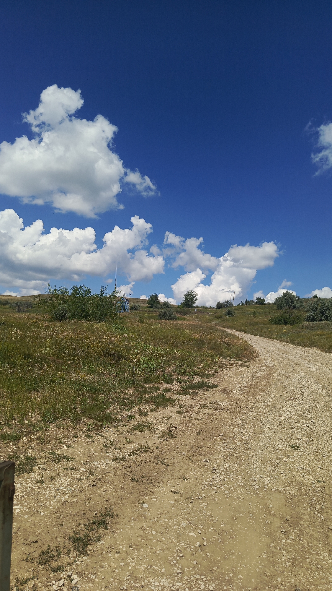 Winding dirt road through sunny Russian countryside hills