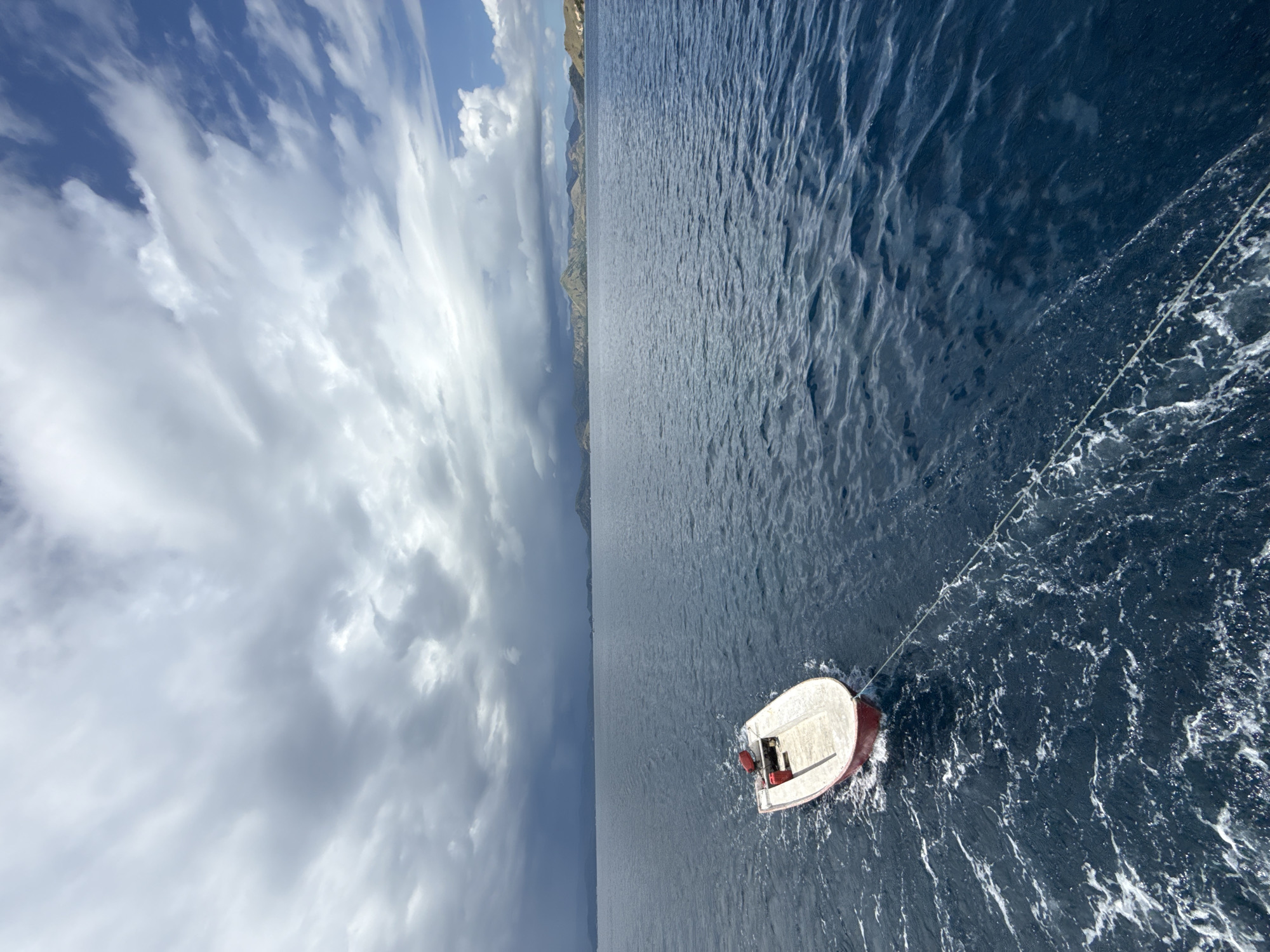Small boat towed across waters near Pasir Putih, Indonesia