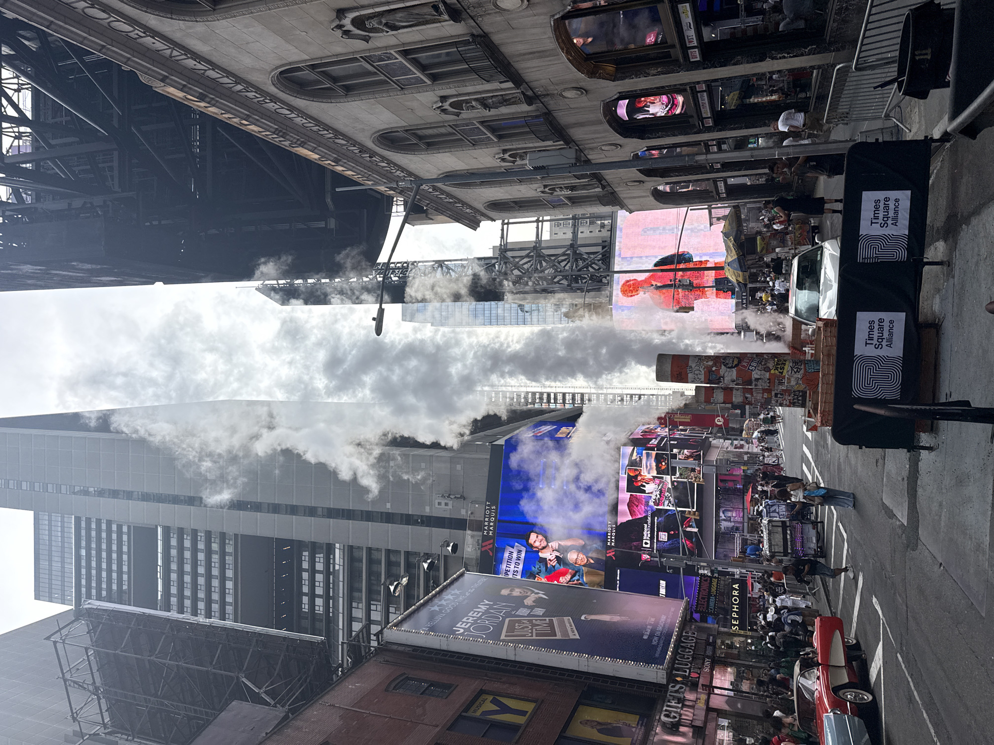 Times Square traffic and steam vents on a July evening