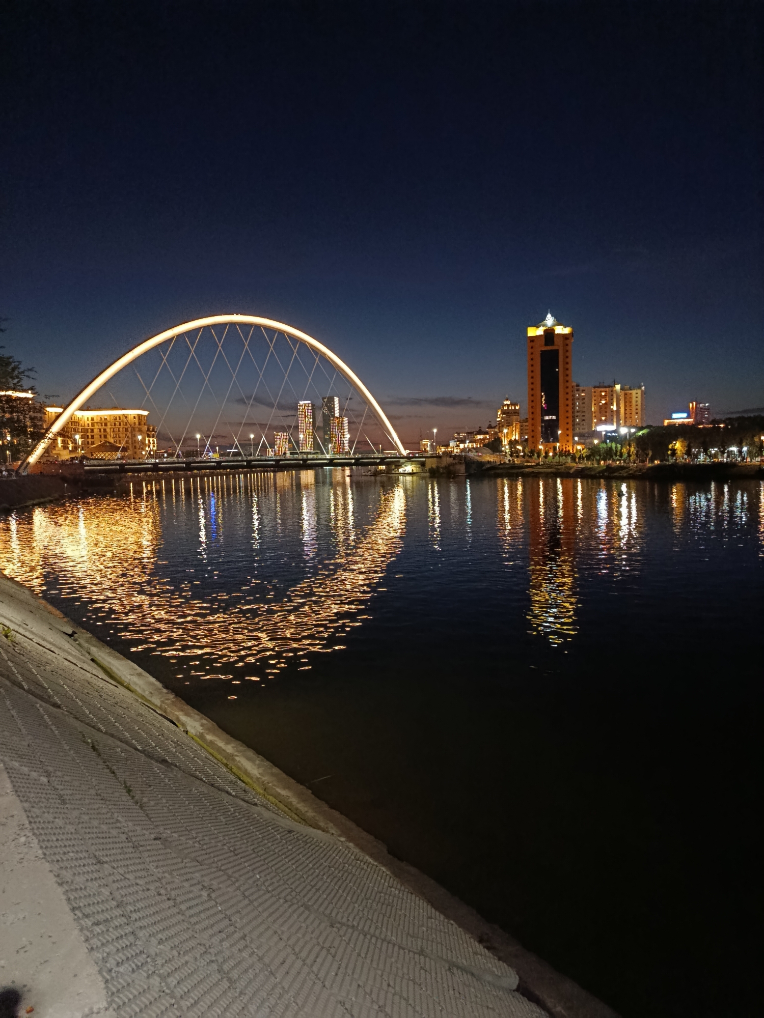 Nighttime stroll along Astana's Ishim River embankment