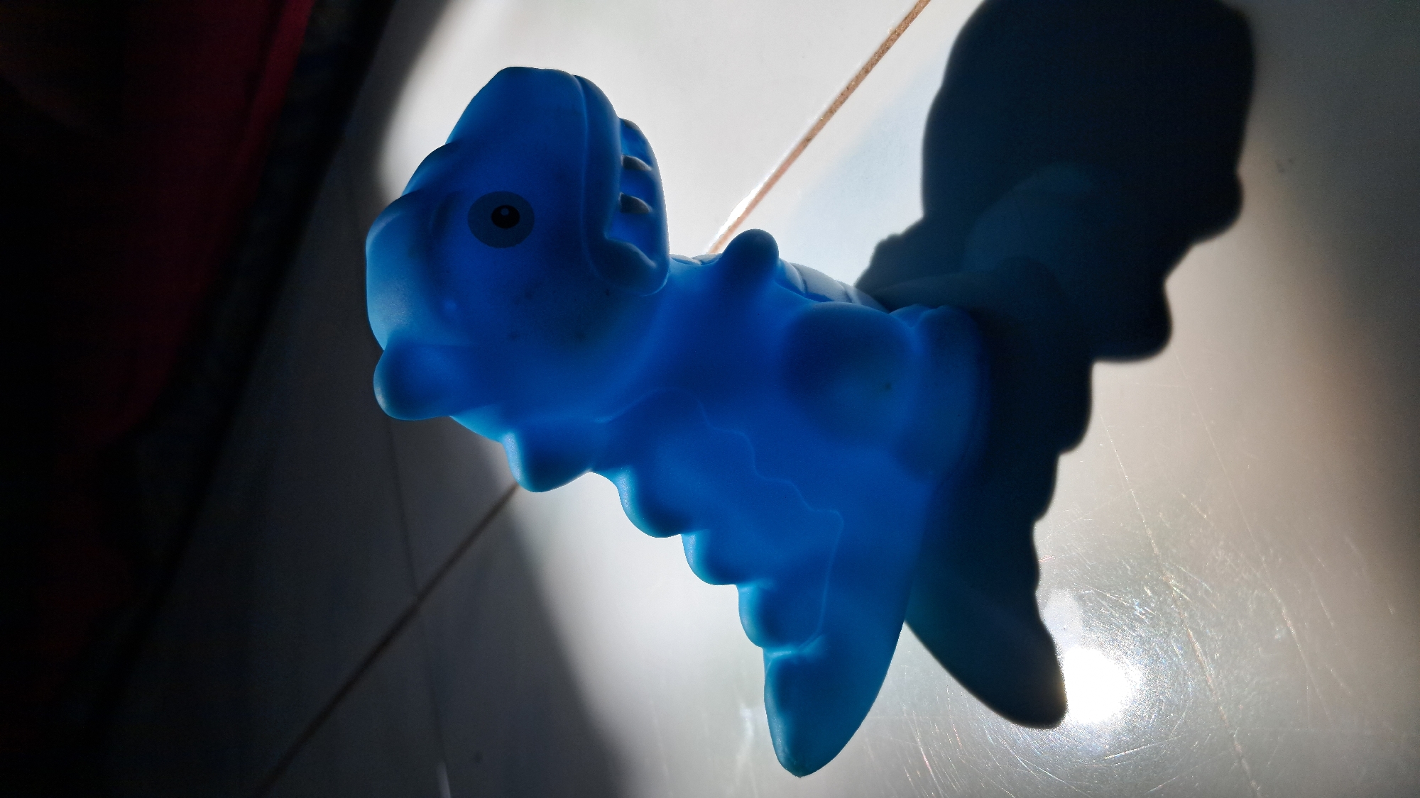 Blue toy dinosaur photographed in Lhokseumawe, Indonesia