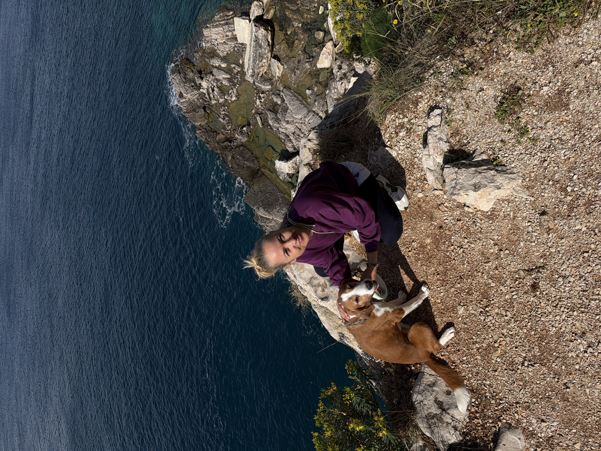 Woman and dog enjoy morning cliff walk in Montenegro