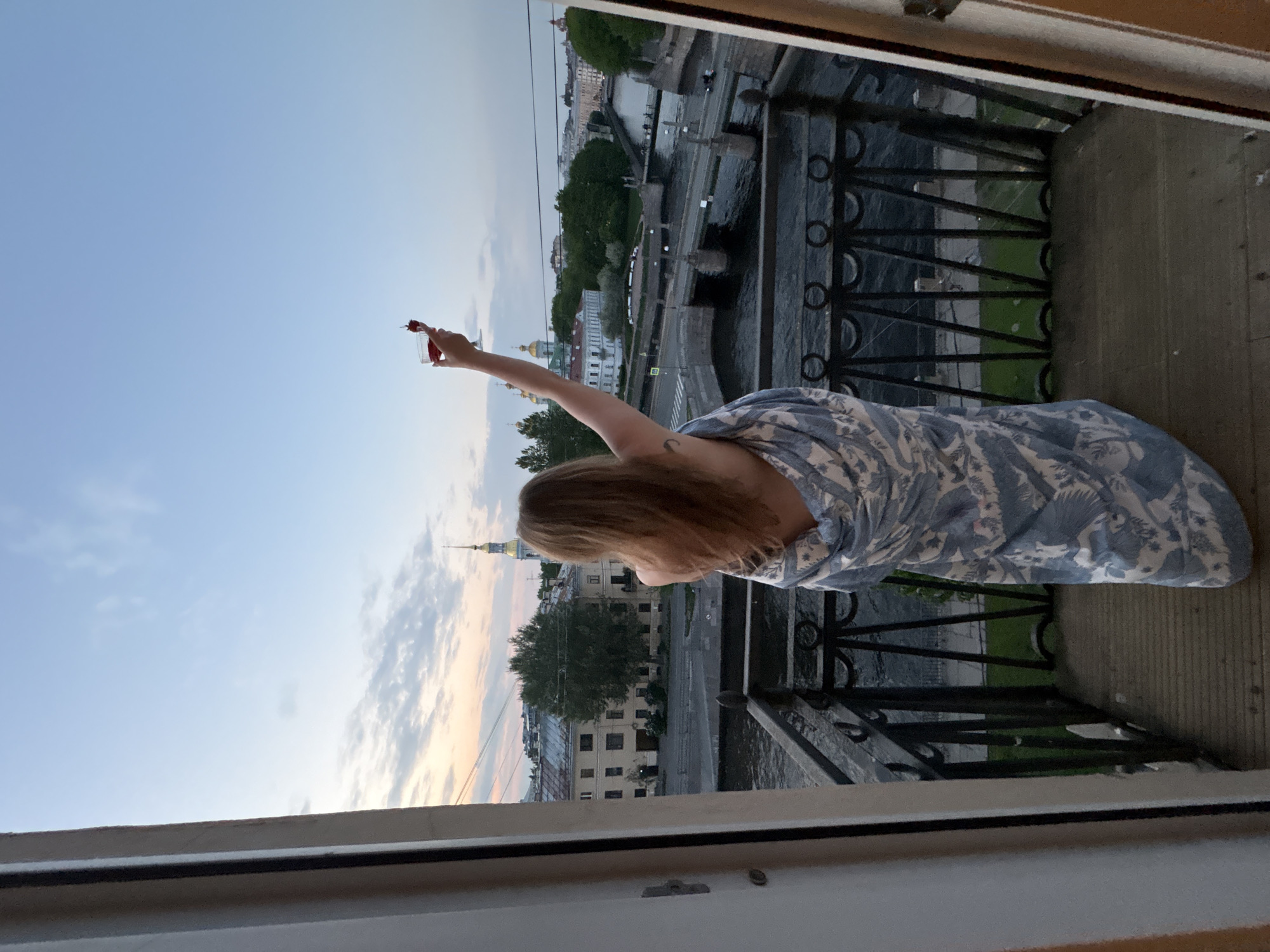 Woman enjoys strawberry cocktails on St. Petersburg balcony